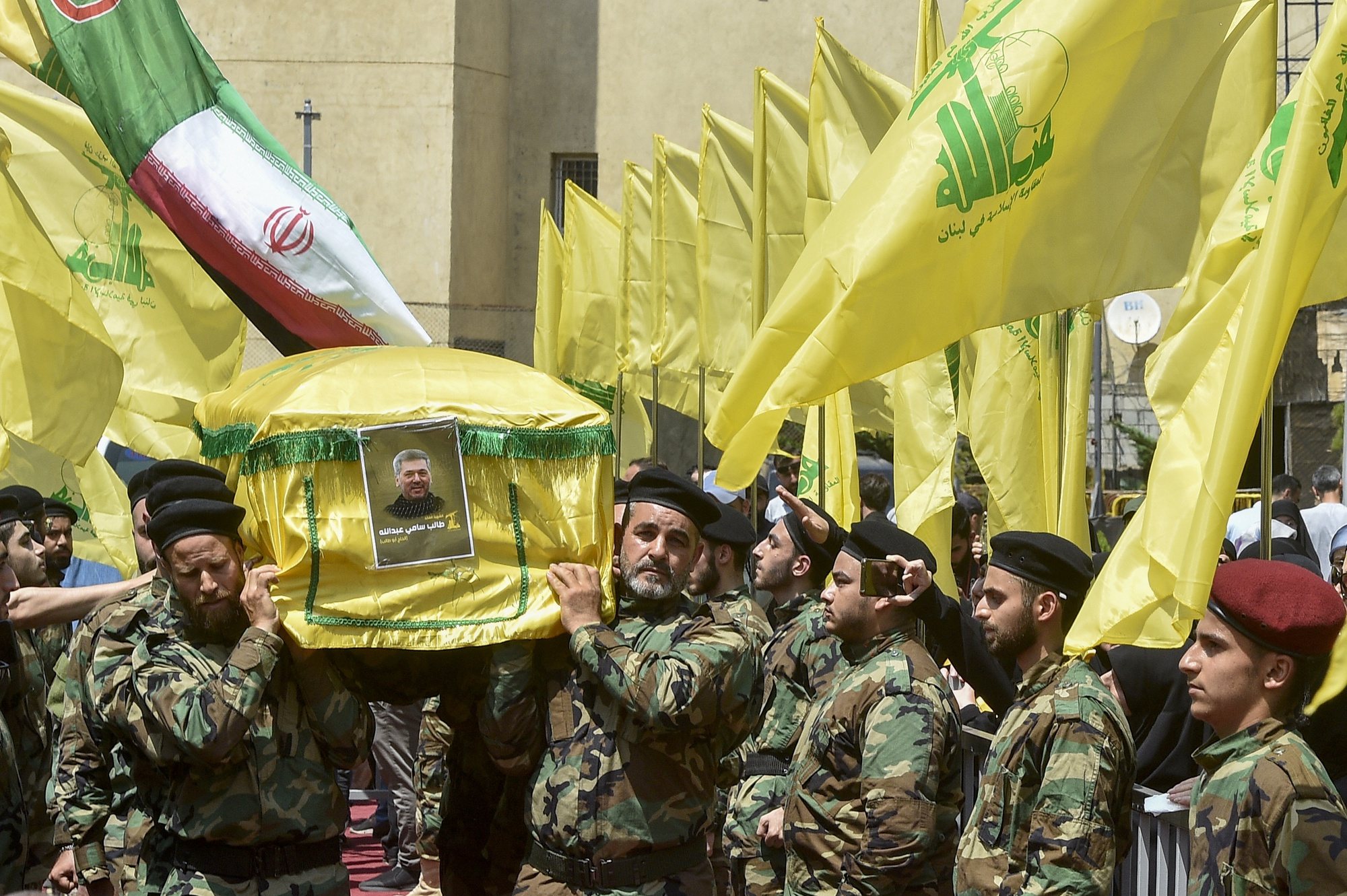 epa11405815 Hezbollah fighters carry the coffin of late Hezbollah senior commander Taleb Sami Abdallah during a funeral procession in Beirut, Lebanon, 12 June 2024. According to the Hezbollah media office, four Hezbollah fighters, including the senior leader Taleb Sami Abdallah, were killed after the Israeli attack on a residential building in Jwaya town in the Tyre district, southern Lebanon on 11 June.  EPA/WAEL HAMZEH