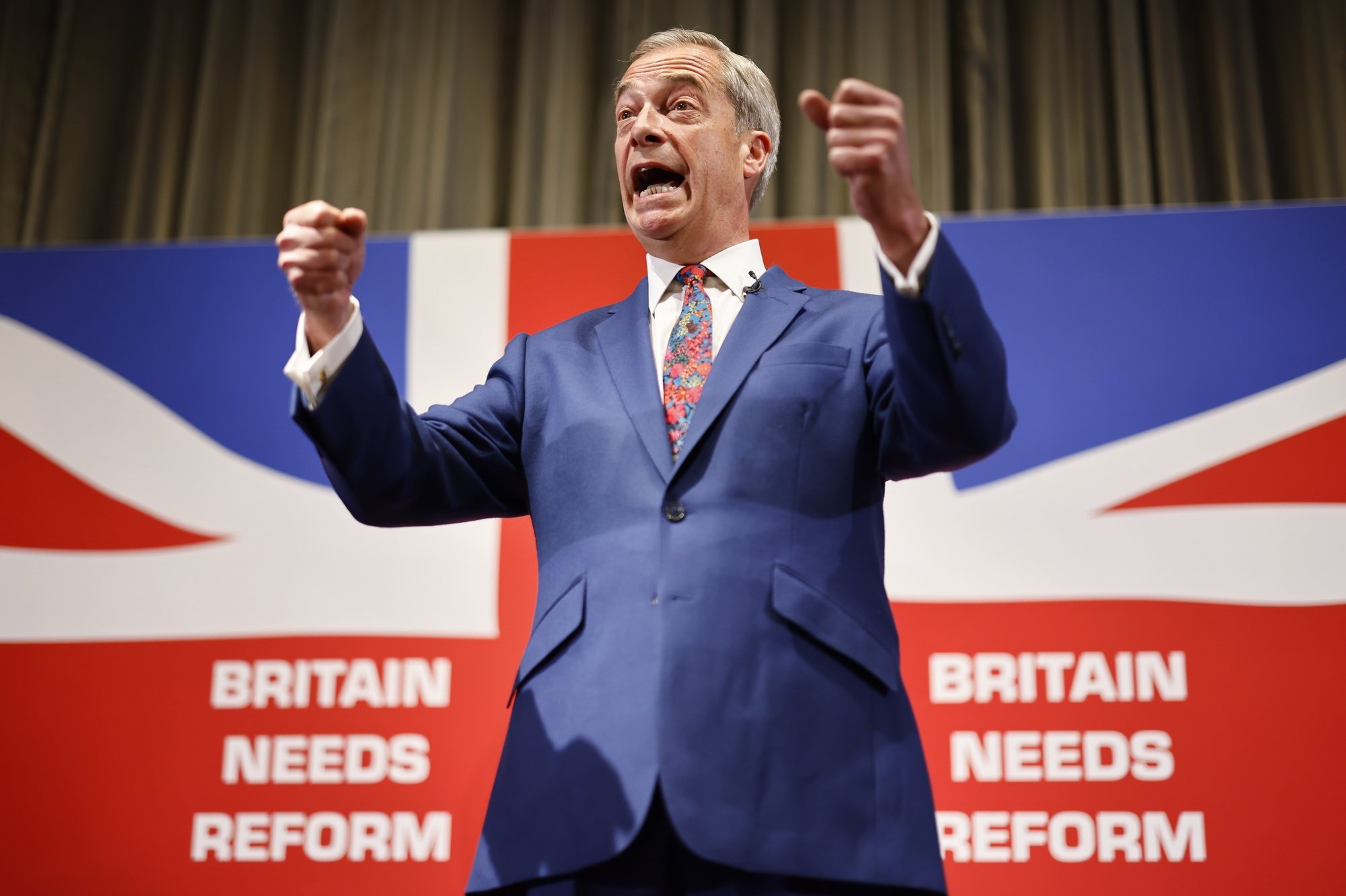 epaselect epa11379338 Honorary President of Reform UK Nigel Farage gestures while speaking at a press conference for the Reform UK party at the Glaziers Hall, London, Britain, 30 May 2024. Britain will hold a snap general election on 04 July 2024.  EPA/TOLGA AKMEN