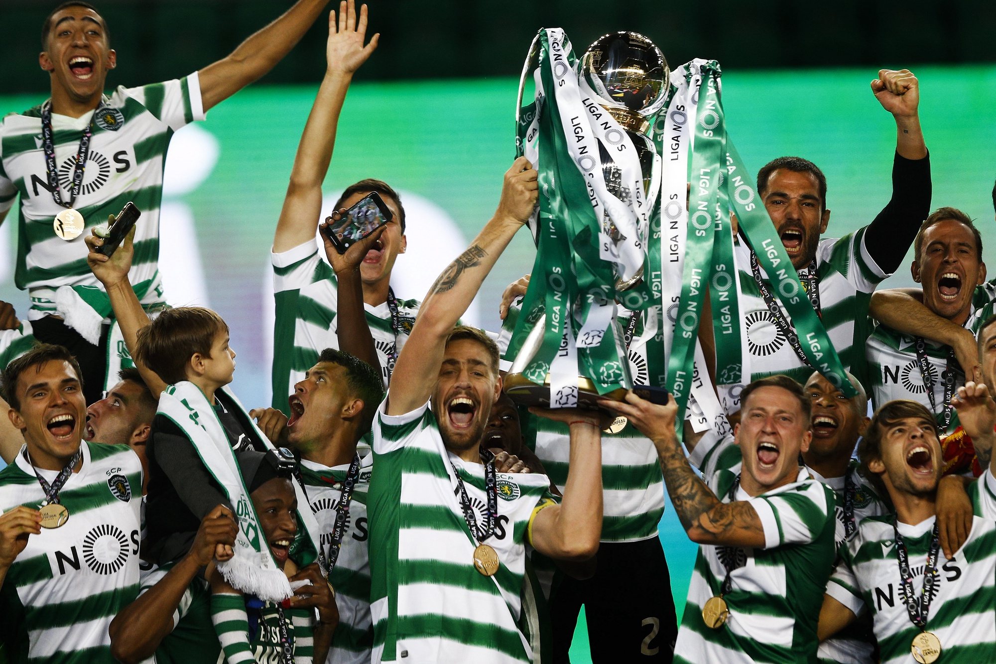 epa09192621 Sporting Lisbon&#039;s players hold the trophy as they celebrate the Portuguese First League title after defeating Boavista FC in their match held at Alvalade Stadium, Lisbon, Portugal, 11 May 2021.  EPA/ANTONIO COTRIM