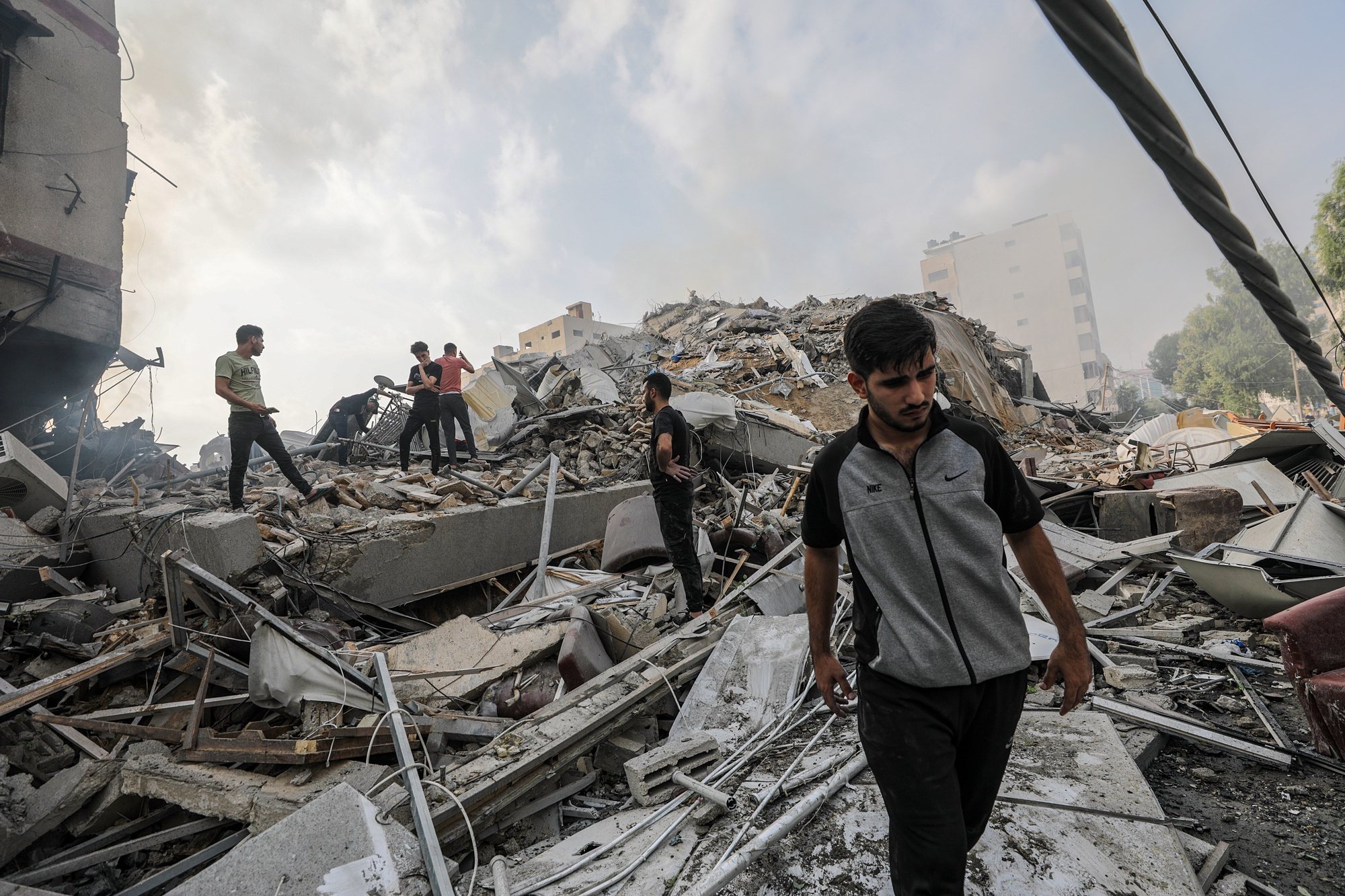 epa10907061 Palestinians inspect the rubble of their destroyed homes near Al-Watan Tower in Gaza City, 08 October 2023, following Israeli air strikes. The air strikes, in retaliation for the 07 October Hamas rocket attacks on Israel, caused the 14-storey building to collapse. Israeli air strikes have killed over 300 people in the Gaza Strip, with almost 2,000 wounded, according to Palestinian official sources.  EPA/MOHAMMED SABER
