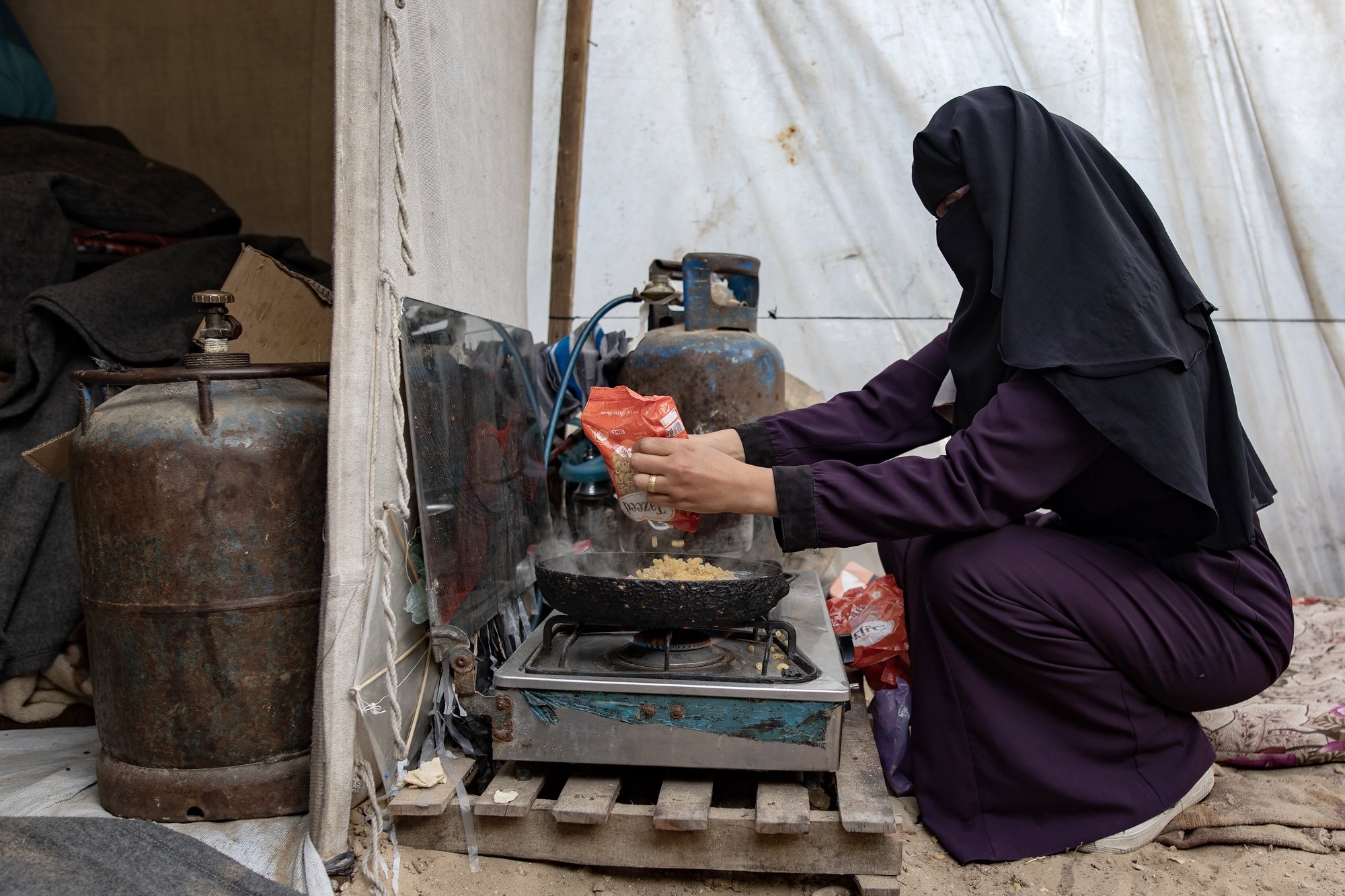 epa11235176 Internally displaced Palestinian Hanan Al-Shafi&#039;i &#039;Umm Adl&#039;, 30, a mother to nine children, cooks on a stove, at their shelter in Khan Yunis, southern Gaza Strip, 21 March 2024. Hanan said that she and her children have been displaced twice within Khan Yunis since the outbreak of the conflict. With no access to fresh water, her children walk long distances to fetch water to meet their daily needs of 40 liters of clean water for drinking and cooking and 70 liters for washing and personal hygiene. According to the United Nations, the majority of people in the Gaza Strip face dire water and sanitation conditions as WASH (water, sanitation, hygiene) facilities that provide basic services have been damaged or destroyed. Since 07 October 2023, up to 1.9 million people have been displaced throughout the Gaza Strip, according to UNRWA, which added that most civilians in Gaza are in &#039;desperate need of humanitarian assistance and protection&#039;. World Water Day, which is held annually on 22 March, focuses on the importance of global access to safe and clean water. This year&#039;s theme is &#039;Leveraging Water for Peace&#039;.  EPA/HAITHAM IMAD