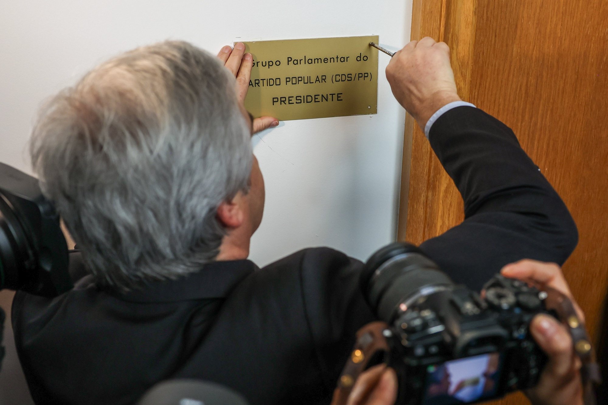 O presidente do CDS-PP, Nuno Melo, recoloca a placa do partido na sala do grupo parlamentar na Assembleia da República, em Lisboa, 26 de março de 2024. JOSÉ SENA GOULÃO/LUSA