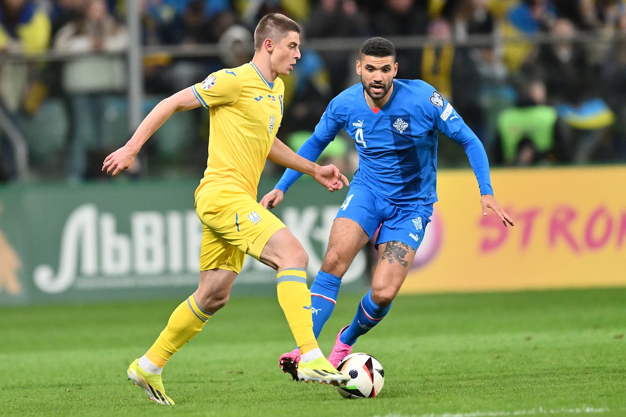 epa11245512 Georgiy Sudakov (L) of Ukraine and Victor Palsson (R) of Iceland in action during the UEFA EURO 2024 play-offs final match between Ukraine and Iceland in Wroclaw, Poland, 26 March 2024.  EPA/Maciej Kulczynski POLAND OUT