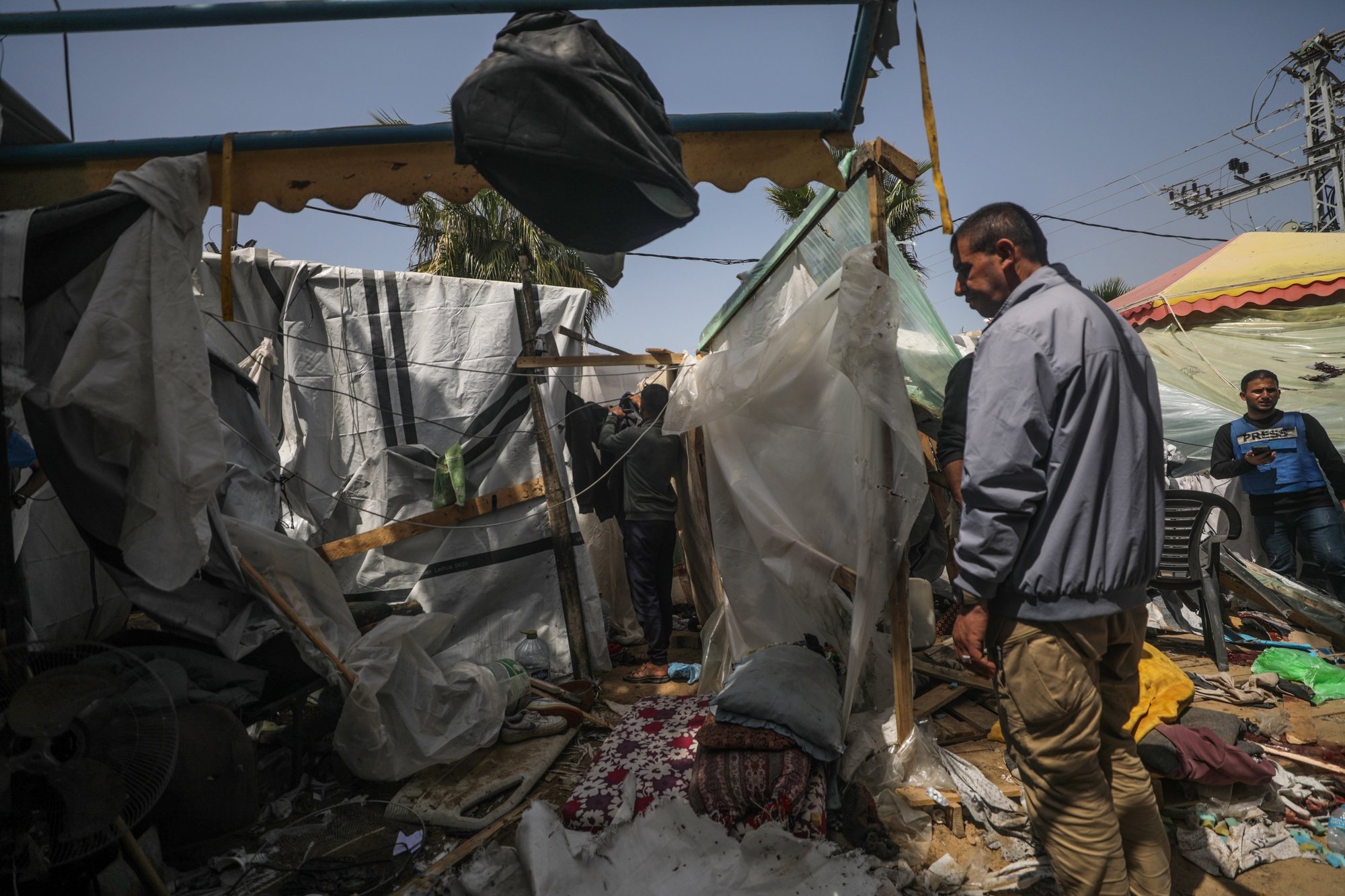 epaselect epa11252939 Palestinians inspect a destroyed shelter tents following an Israeli air strike near Al Aqsa hospital, in Deir Al Balah town in southern Gaza Strip, 31 March 2024. Three Palestinian journalists were wounded and two displaced persons were killed in the air strike, according to Palestinian Civilian Defence. More than 32,700 Palestinians and over 1,450 Israelis have been killed, according to the Palestinian Health Ministry and the Israel Defense Forces (IDF), since Hamas militants launched an attack against Israel from the Gaza Strip on 07 October 2023, and the Israeli operations in Gaza and the West Bank which followed it.  EPA/MOHAMMED SABER