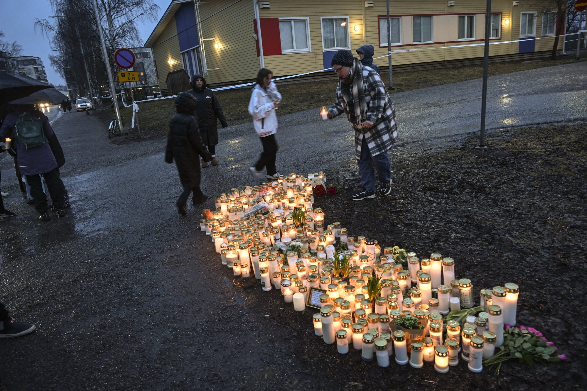 epa11255796 People leave candles in the school yard where a shooting incident took place in Vantaa, Finland, 02 April 2024. According to Police, one 12-year-old child has died and two others are injured in a shooting incident in a school in Vantaa. The suspect, also aged 12, fled the scene but was later arrested.  EPA/KIMMO BRANDT