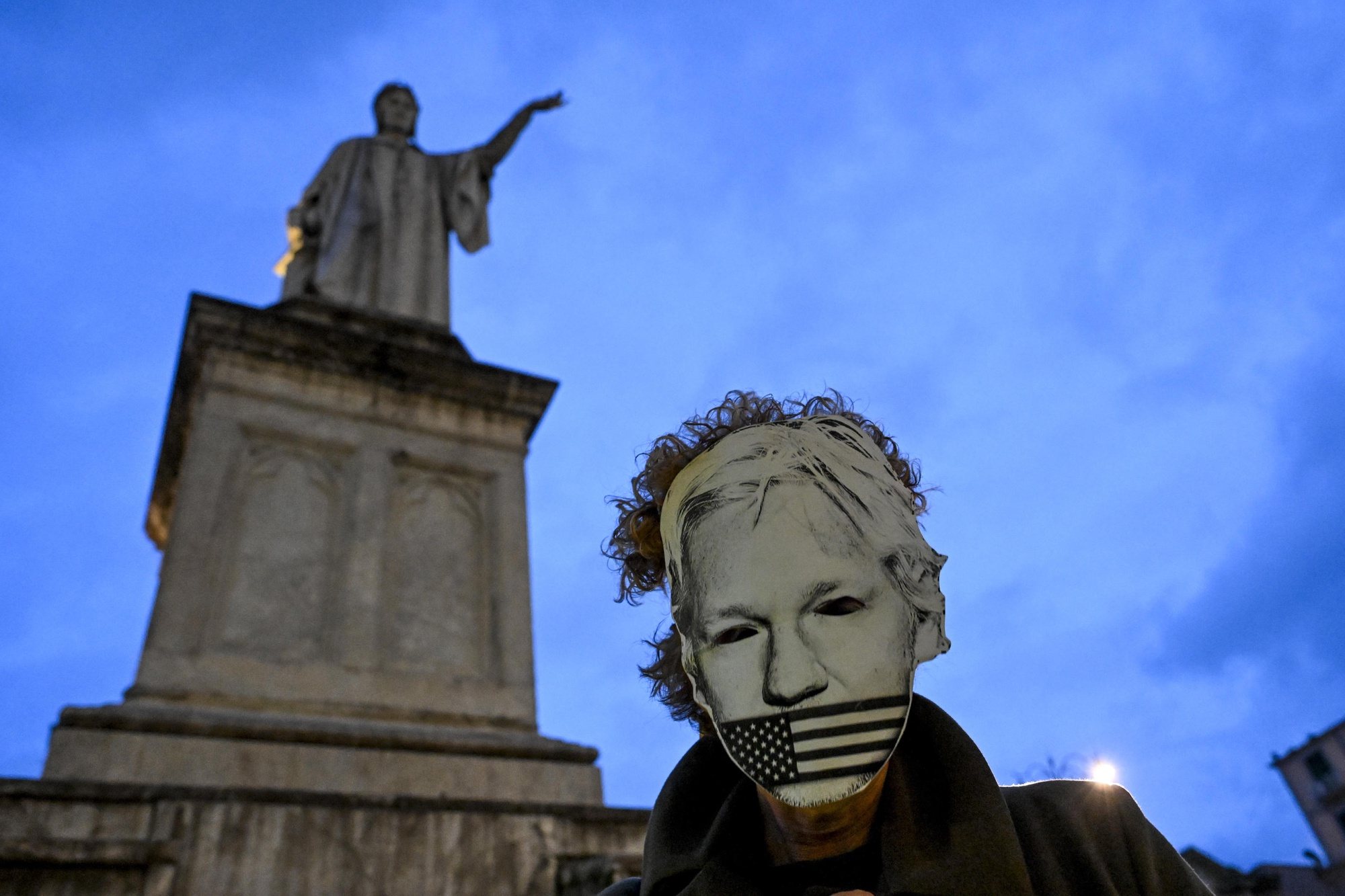epaselect epa11245138 A supporter of WikiLeaks founder Julian Assange wears a face mask while demonstrating among others near the Monument to Dante in Naples, Italy, 26 March 2024. According to a press statement by Courts and Tribunals Judiciary on 26 March, the High Court has granted Assange conditional permission to appeal his extradition to the US. The US was given a three weeks period to ensure that Assange will not be sentenced to death, that he will be afforded his first amendment rights (free speech) and that his Australian nationality will not be a prejudice in case of trial. The next hearing is due for 20 May, to review whether the latest conditions have been met.  EPA/CIRO FUSCO