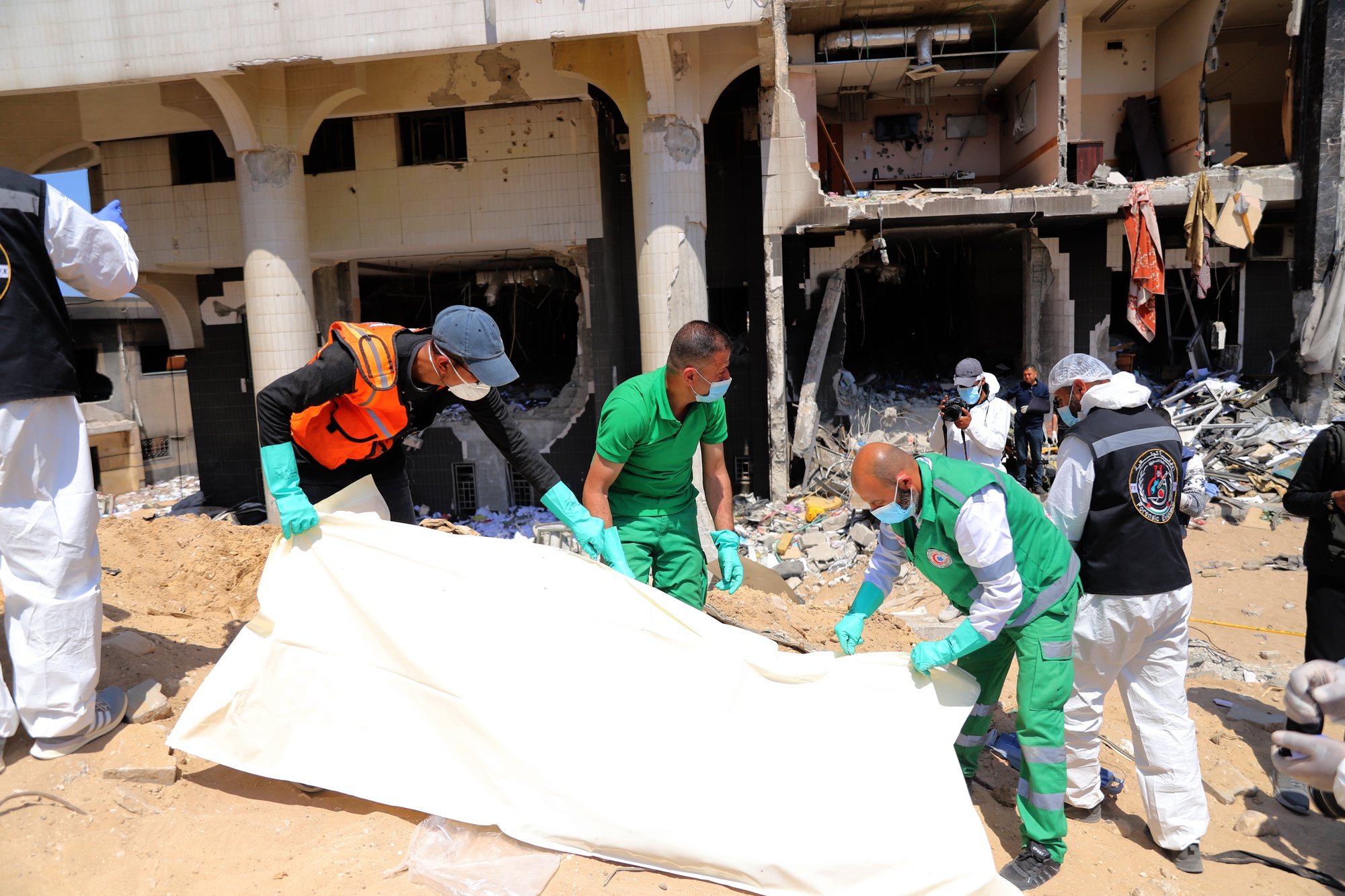 epa11265682 Crew members from the Palestinian ministries of health, justice, and interior examine a body recovered among the rubble after the Israeli army had left the Al-Shifa Medical Hospital Complex in Gaza City, 08 April 2024. According to the Israeli army spokesperson, approximately 500 suspects affiliated with Hamas were apprehended and 200 were eliminated. More than 33,000 Palestinians and over 1,450 Israelis have been killed, according to the Palestinian Health Ministry and the Israel Defense Forces (IDF), since Hamas militants launched an attack against Israel from the Gaza Strip on 07 October 2023, and the Israeli operations in Gaza and the West Bank which followed it.  EPA/MOHAMED HAJJAR