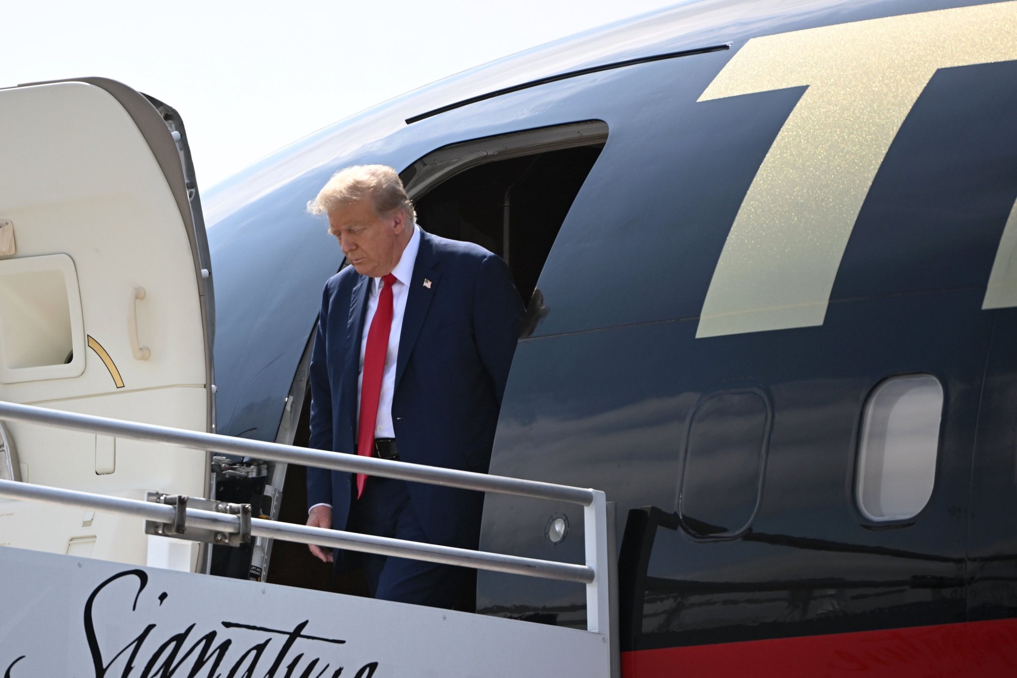 epa11270700 Former president Donald J. Trump walks off his plane at Hartsfield-Jackson Atlanta International Airport, in Atlanta, Georgia, USA, 10 April 2024, as he arrives for a political fundraiser.  EPA/EDWARD M. PIO RODA