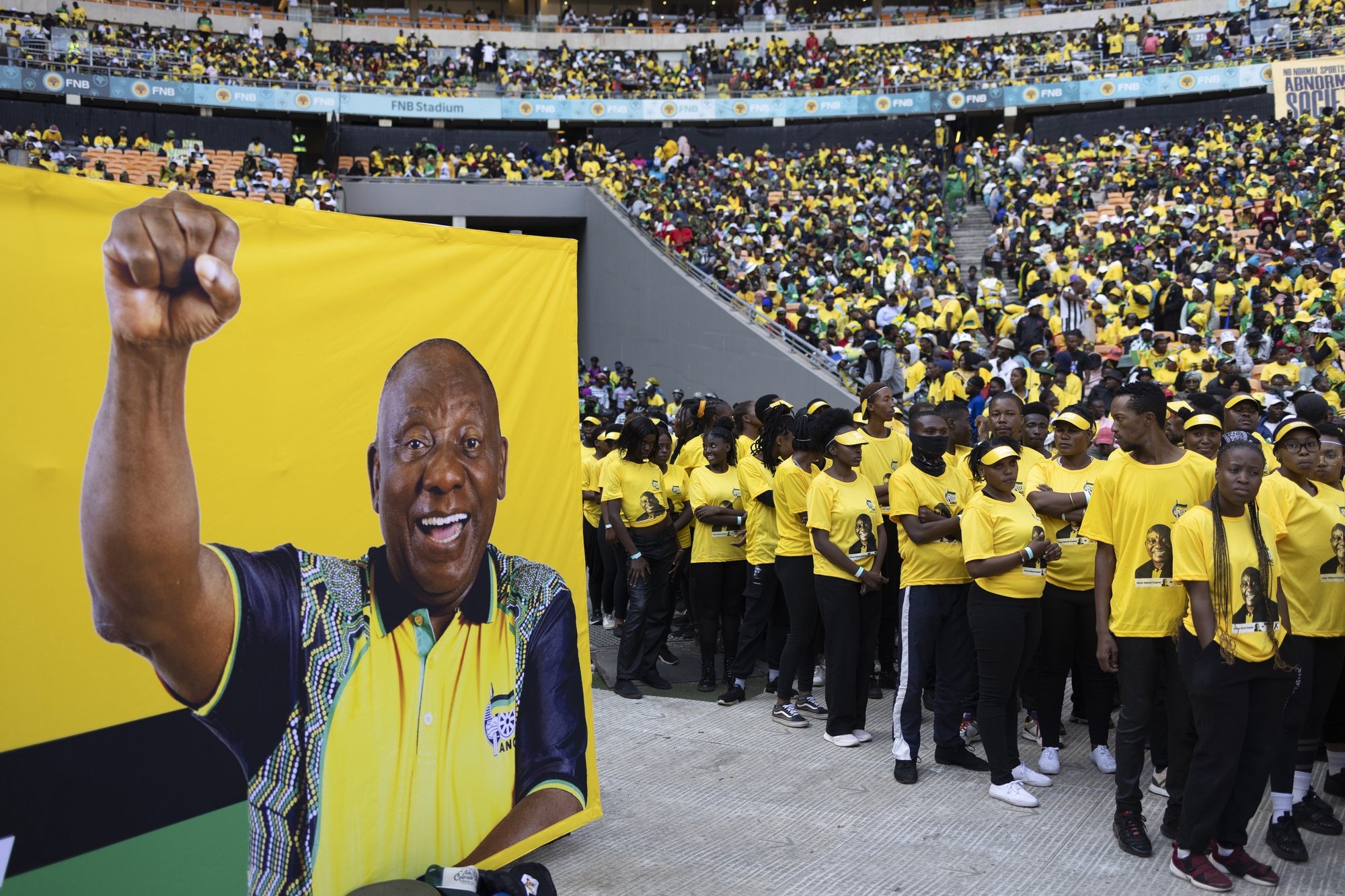 epa11368474 Performers stand next to a banner with a picture of South African President Cyril Ramaphosa during the African National Congress Party (ANC) final election rally held at the FNB Stadium in Soweto, Johannesburg, South Africa, 25 May 2024. The final election campaign rallies by all major parties will be held over the weekend as the country prepares for general elections on 29 May. The elections come 30 years after the end of Apartheid and the first free and fair elections in the country.  EPA/KIM LUDBROOK