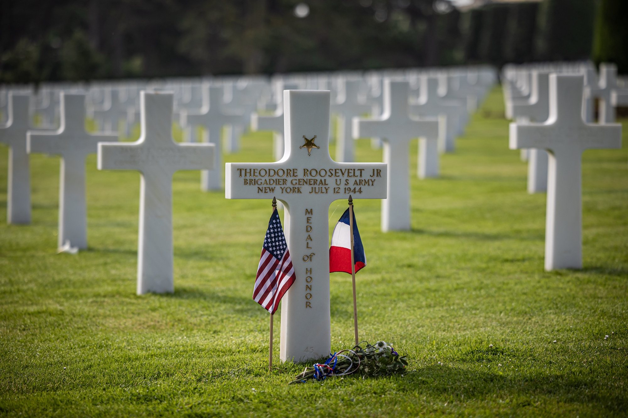 epa11387454 US and French flags are placed on the grave of Theodore Roosevelt Jr., the late military leader and son of American President Theodore Roosevelt, at the American Cemetery ahead of the 80th D-Day anniversary, in Colleville-sur-Mer, Normandy, France, 03 June 2024. World leaders are due to attend memorial events in Normandy, France on 06 June 2024 to mark the 80th anniversary of the D-Day landings, when allied forces invaded German controlled France.  EPA/CHRISTOPHE PETIT TESSON