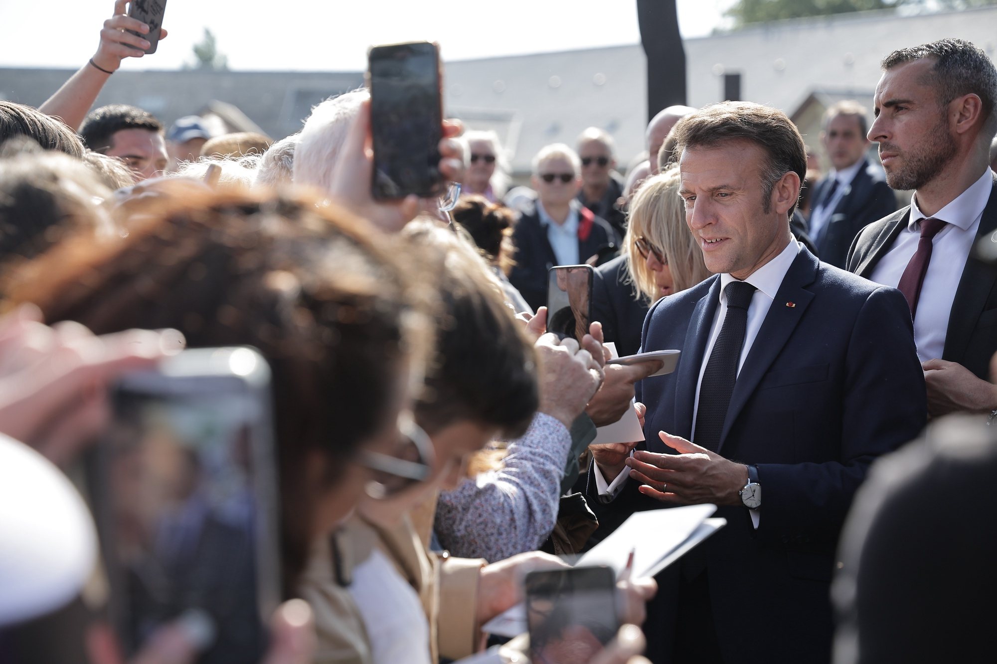 epa11391686 French President Emmanuel Macron (2-R) meets local residents during a ceremony in tribute to the civilian victims of World War II, ahead of celebrations for the 80th anniversary of D-Day landing in Normandy, in Saint-Lo, France, 05 June 2024. The City of Saint-Lo was almost razed by allied bombings on 06 and 07 June 1944 aiming to cut off communication ways for the German occupants. Around 20,000 civilians were killed during the Normandy Battle in Summer of 1944, following the allied landing on 06 June.  EPA/CHRISTOPHE PETIT TESSON / POOL