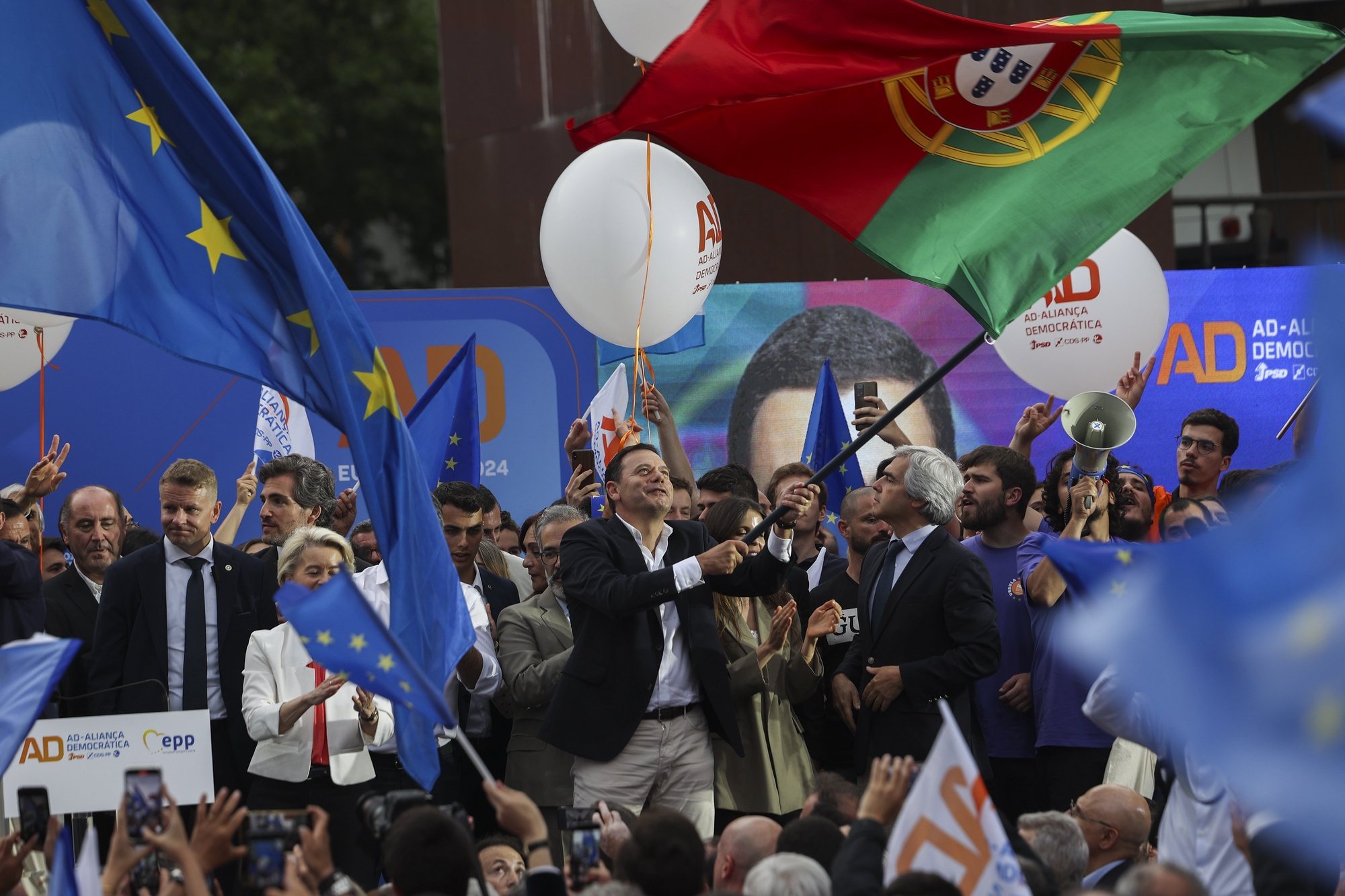 PSD (Social Democratic Party) leader, Luis Montenegro (C), holds a portuguese flag during a Democratic Alliance (AD) rally as part of the campaign for the European elections, Porto, Portugal, on 6th June 2024. TIAGO PETINGA/LUSA