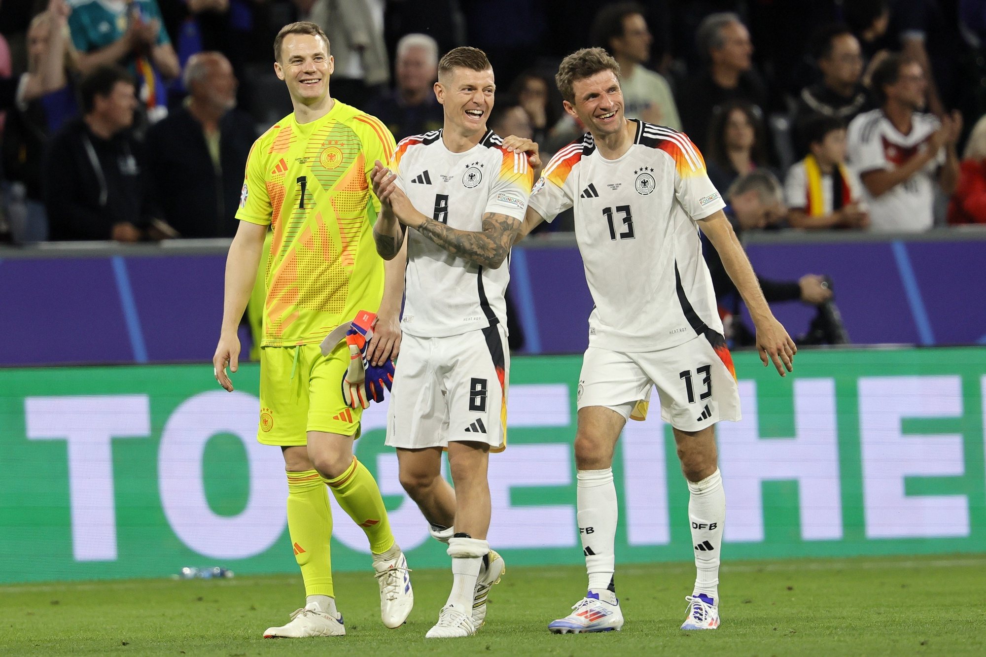 epa11411132 (L-R) Goalkeeper Manuel Neuer, Toni Kroos, and Thomas Muller of Germany laugh as they greet supporters after winning the UEFA EURO 2024 group A match between Germany and Scotland in Munich, Germany, 14 June 2024.  EPA/RONALD WITTEK