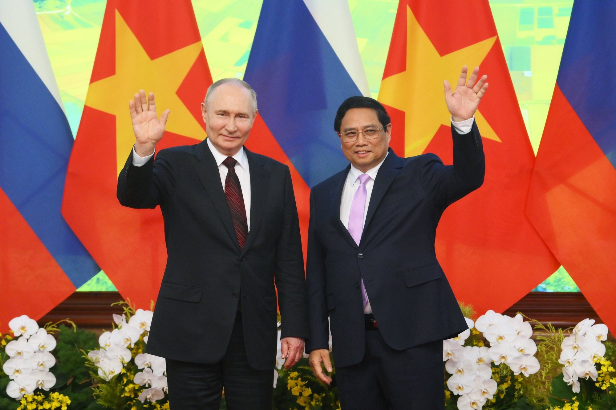 epa11424543 Russian President Vladimir Putin (L) and Vietnamese Prime Minister Pham Minh Chinh wave as they pose for a photo at the Government Office in Hanoi, Vietnam, 20 June 2024. Putin is on an official visit to Vietnam following his visit to North Korea.  EPA/KRISTINA KORMILITSYNA/SPUTNIK/KREMLIN POOL MANDATORY CREDIT