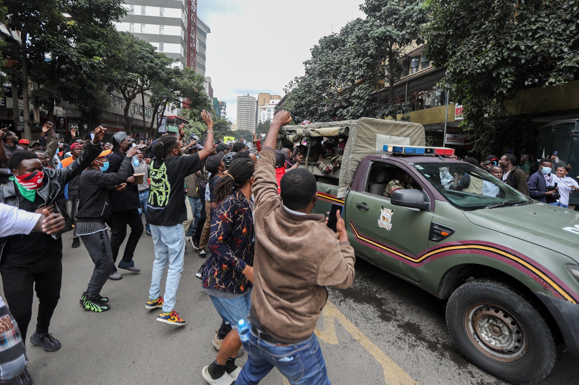 epa11425870 Protesters reacts as members of the security forces drive past, during a demonstration against a controversial tax bill in the central business district in Nairobi, Kenya, 20 June 2024. Police have fired tear gas to disperse protesters who gathered near the parliament to demonstrate against planned tax hikes that many fear will worsen the cost-of-living crisis.  EPA/DANIEL IRUNGU