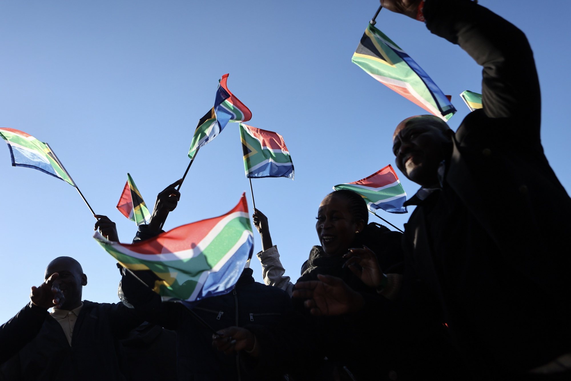 epaselect epa11421632 Supporters wave South African flags while waiting for the start of Cyril Ramaphosa&#039;s inauguration ceremony as South African president at the Union Buildings in Pretoria, South Africa, 19 June 2024. Ramaphosa was re-elected as South Africa&#039;s president by the National Assembly on 14 June 2024, following the country&#039;s general elections held on 29 May 2024.  EPA/ALAISTER RUSSELL