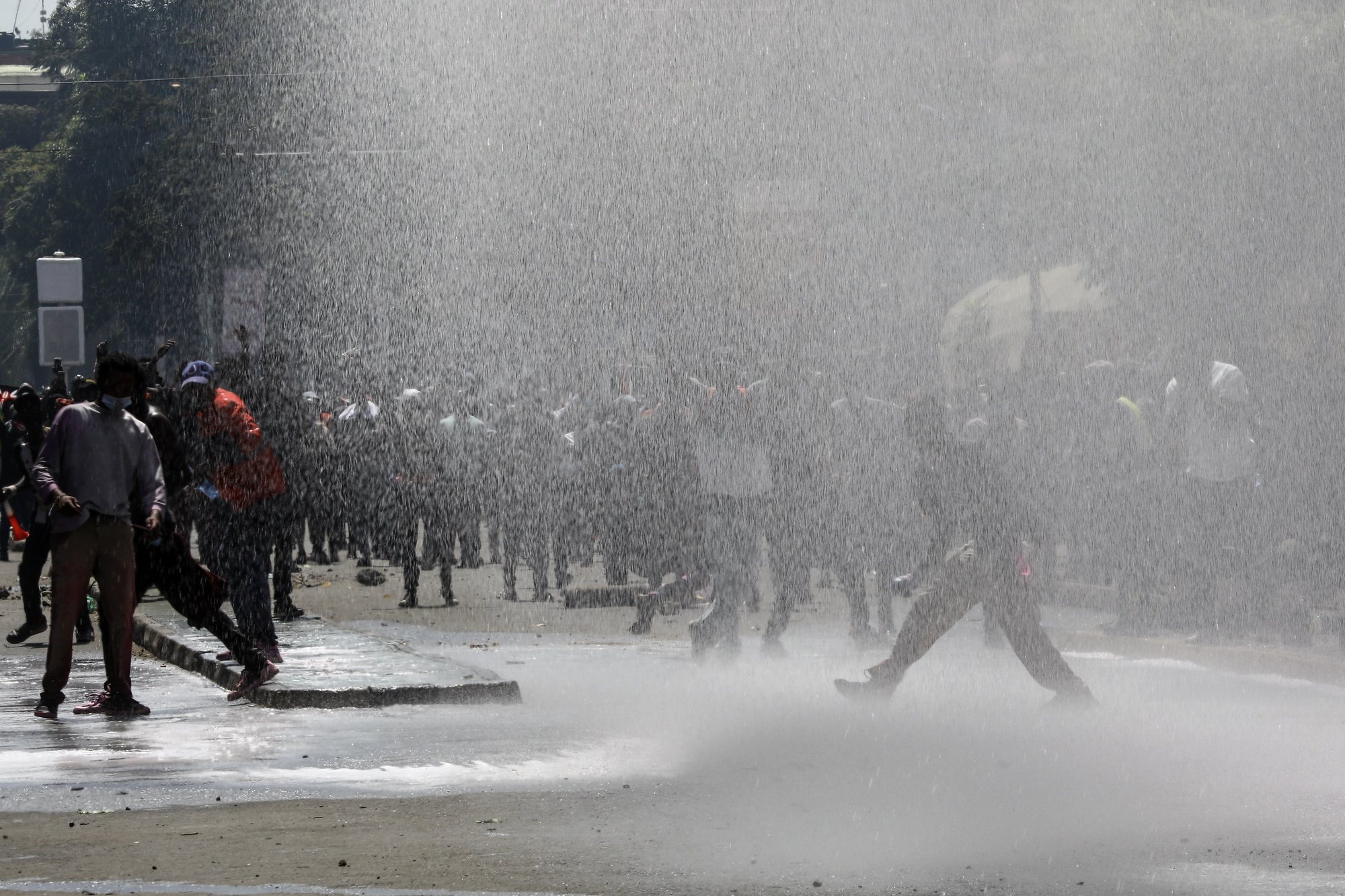 epa11436112 Demonstrators react as police use a water cannon and fire teargas during a protest against proposed tax hikes, in Nairobi, Kenya, 25 June 2024. Kenya&#039;s police on 25 June have sealed off the parliament and State House, and fired tear gas to disperse protesters demonstrating against planned tax hikes that many fear will worsen the cost-of-living crisis.  EPA/DANIEL IRUNGU