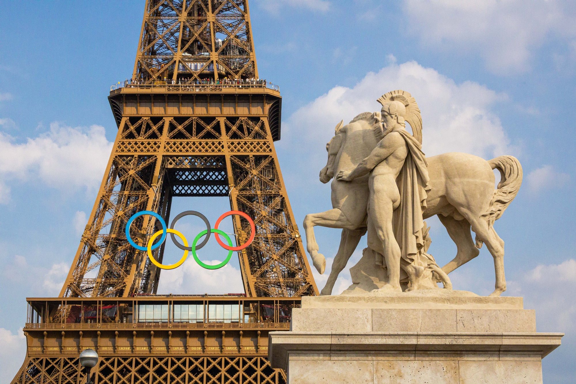 epa11439905 The Eiffel tower decorated with the Olympic rings seen from the working site of the opening ceremony at the Trocadero in Paris, France, 26 June 2024. The opening ceremony of the Paris 2024 Olympic Games will begin with a nautical parade on the Seine and ends on the protocol stage in front of the Eiffel Tower on 26 July 2024.  EPA/CHRISTOPHE PETIT TESSON