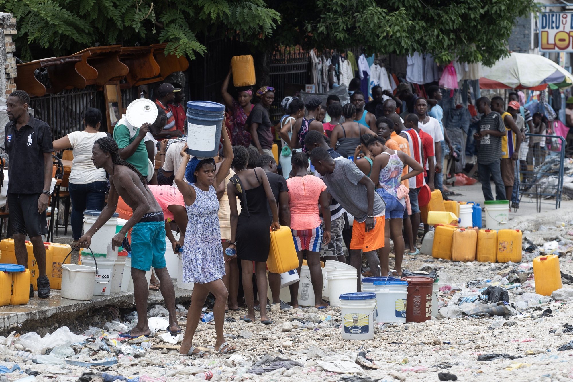 epa11389986 Citizens walk with containers for water collection in Port-au-Prince, Haiti, 04 June 2024. Amnesty International (AI) expressed on 04 June its concern over the &#039;lack of transparency&#039; in relation to the establishment of human rights safeguards for the Multinational Security Support Mission (MSS) in Haiti, expected to deploy in the coming weeks, and calls for these to be respected.  EPA/ORLANDO BARRIA