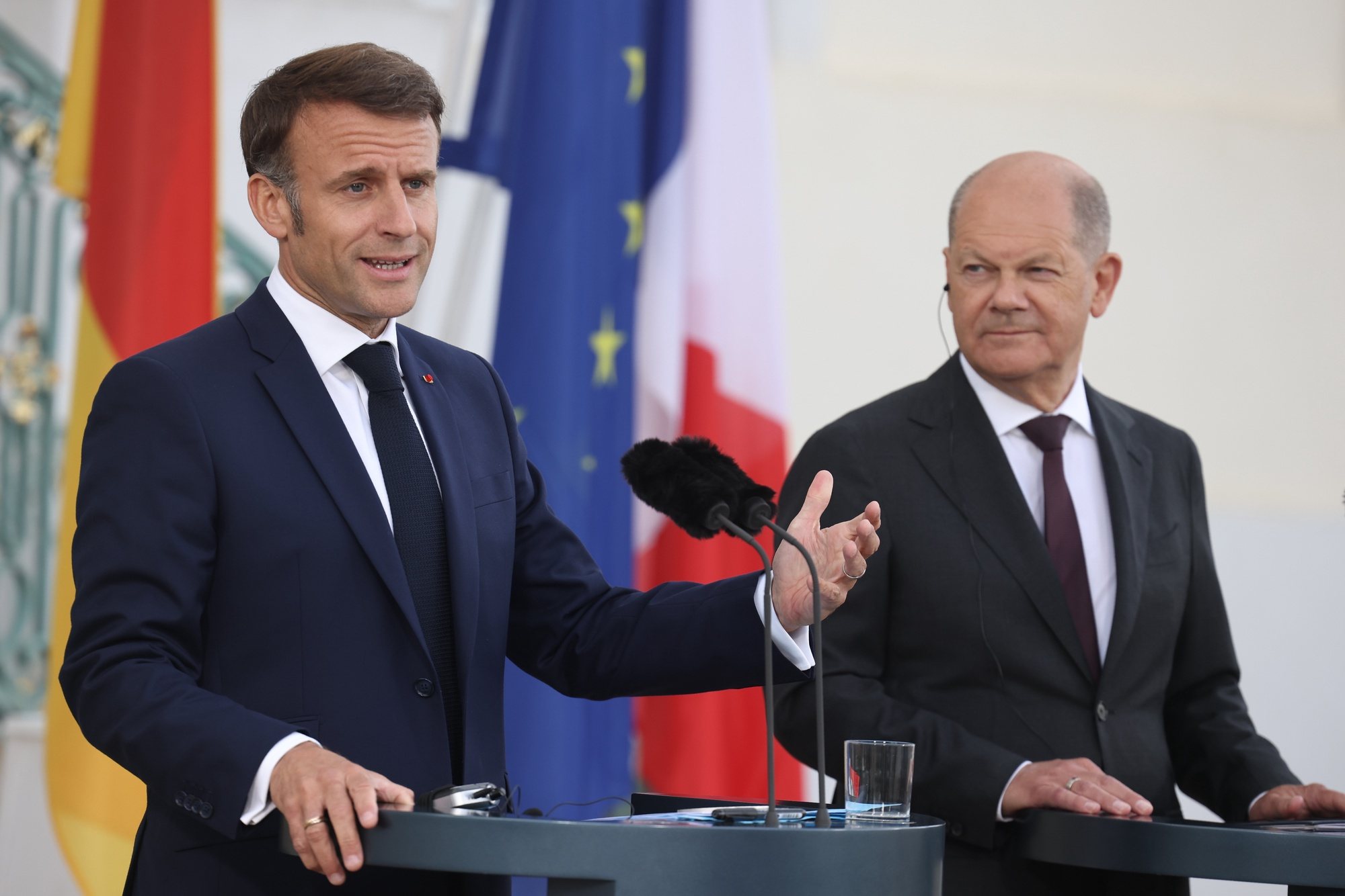 epa11375932 French President Emmanuel Macron (L) gestures next to German Chancellor Olaf Scholz during a joint press conference at Meseberg Palace in Meseberg near Gransee, Germany, 28 May 2024. French President Emmanuel Macron visits Germany from 26 to 28 May. After appointments with Federal President Steinmeier in German regions Berlin, Dresden and Muenster, Macron meets German Chancellor Olaf Scholz at Meseberg Palace on 28 May 2024 for a Franco-German Council of Ministers.  EPA/CLEMENS BILAN