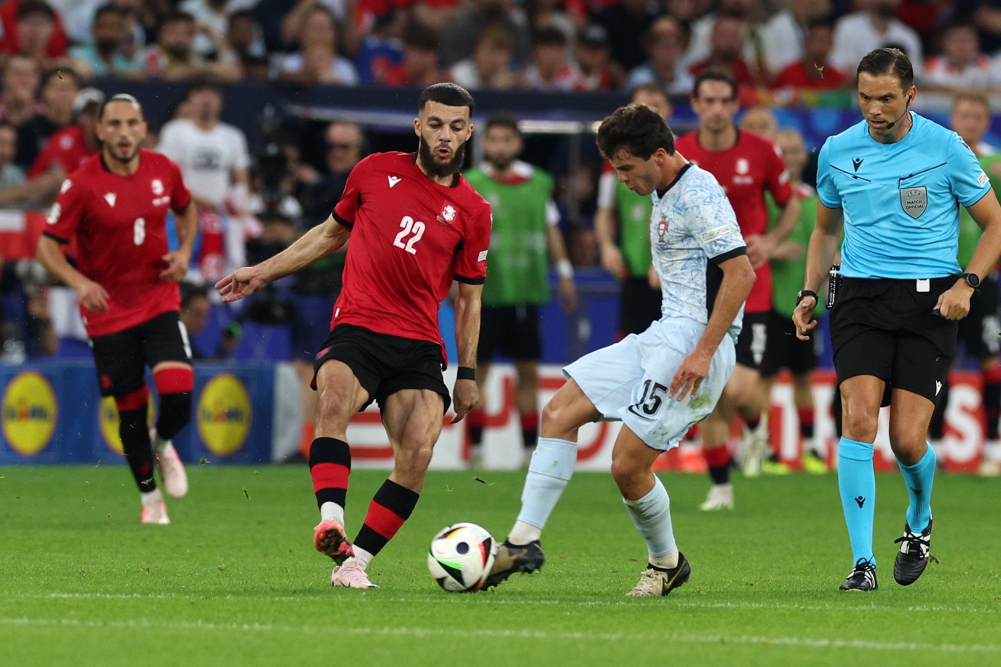 Portugal player Joao Neves (R) in action with Georgia player Georges Mikautadze (L) during the UEFA EURO 2024 group F soccer match, in Gelsenkirchen, Germany, 26 June 2024. MIGUEL A. LOPES/LUSA