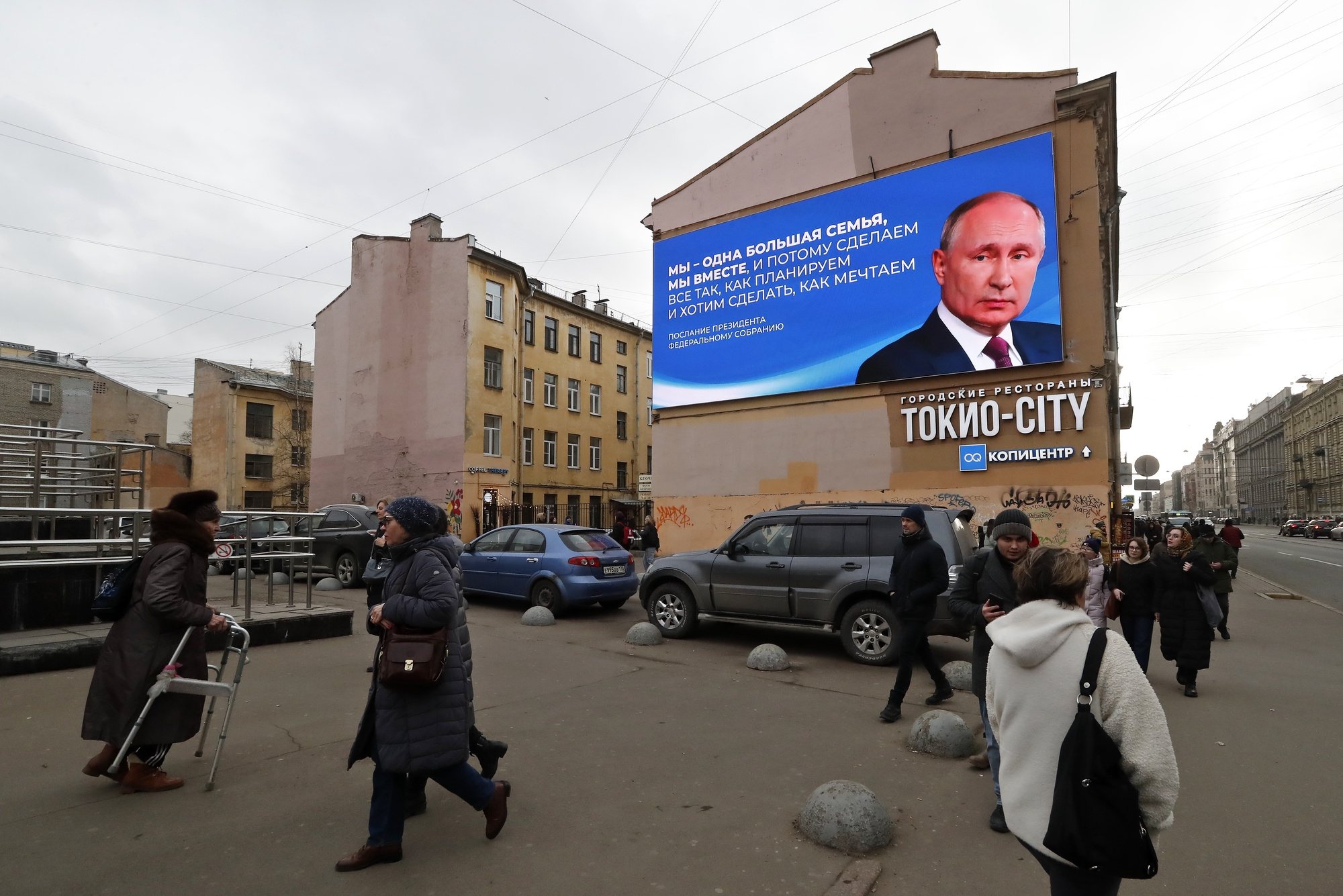 epa11220258 People walk past a huge digital billboard showing Russian President and presidential candidate Vladimir Putin, in St. Petersburg, Russia, 14 March 2024. The Russian presidential elections will be held from 15 to 17 March.  EPA/ANATOLY MALTSEV