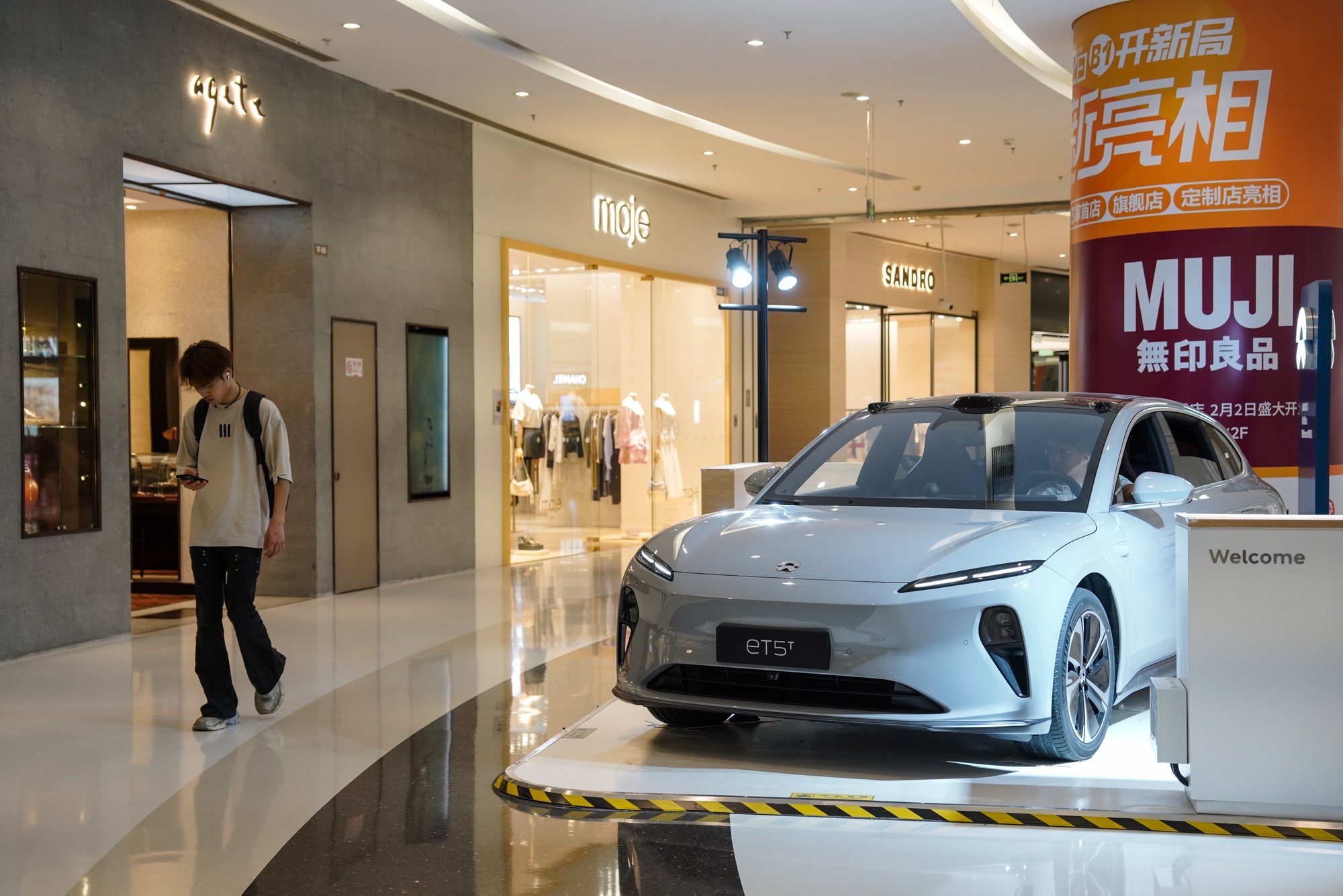 epa11407063 A man walks beside a NIO ET5 electric car on display in a shopping mall in Beijing, China, 13 June 2024. Beijing urges the European Union to reconsider tariffs on Chinese electric vehicles and to stop going further in what they say is the &#039;wrong direction&#039; to protect its auto industry from competition, according to China&#039;s state news agency Xinhua. China said it would take measures to safeguard its interests after the European Commission announced on 12 June it would impose extra duties of up to 38.1 percent on imported Chinese electric vehicles from July 2024.  EPA/WU HAO