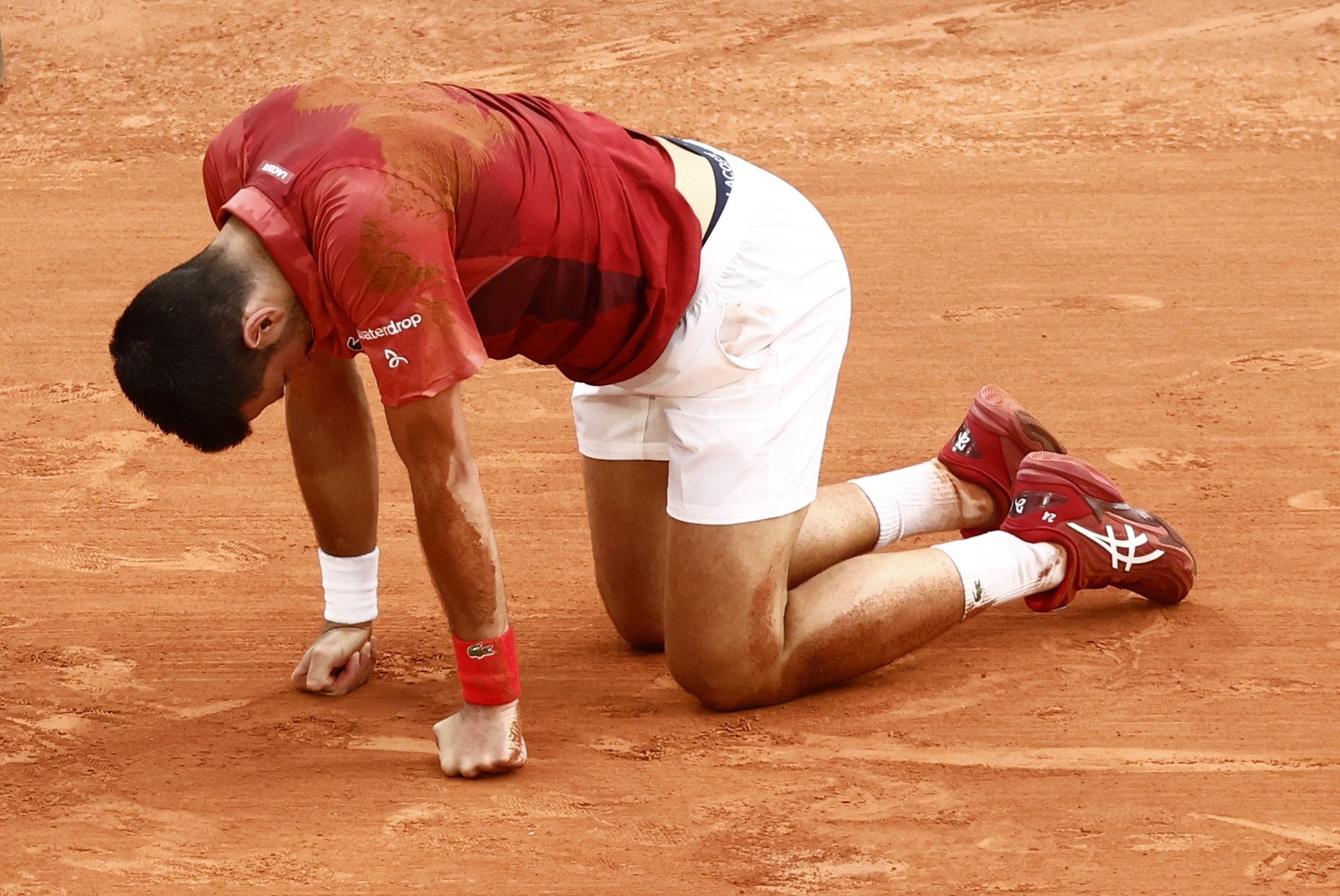 epa11388011 Novak Djokovic of Serbia falls during his men&#039;s singles Round of 16 match against Francisco Cerundolo of Argentina at the French Open Grand Slam tennis tournament at Roland Garros in Paris, France, 03 June 2024.  EPA/YOAN VALAT