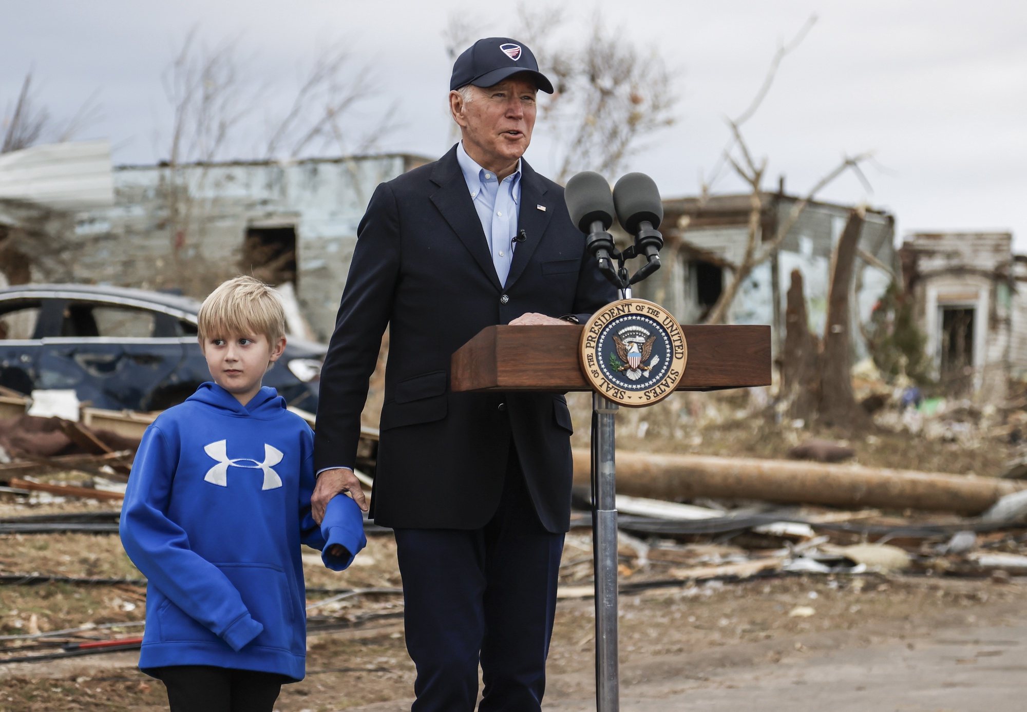epa09644250 US President Joe Biden stands with seven year old Dane Maddox as he visits damage from a tornado that struck on 10 December 2021 that destroyed homes and businesses in Dawson Springs, Kentucky, USA, 15 December 2021. According to the latest tally 74 people people lost their lives in Kentucky and the search for more than 100 still missing continues.  EPA/TANNEN MAURY