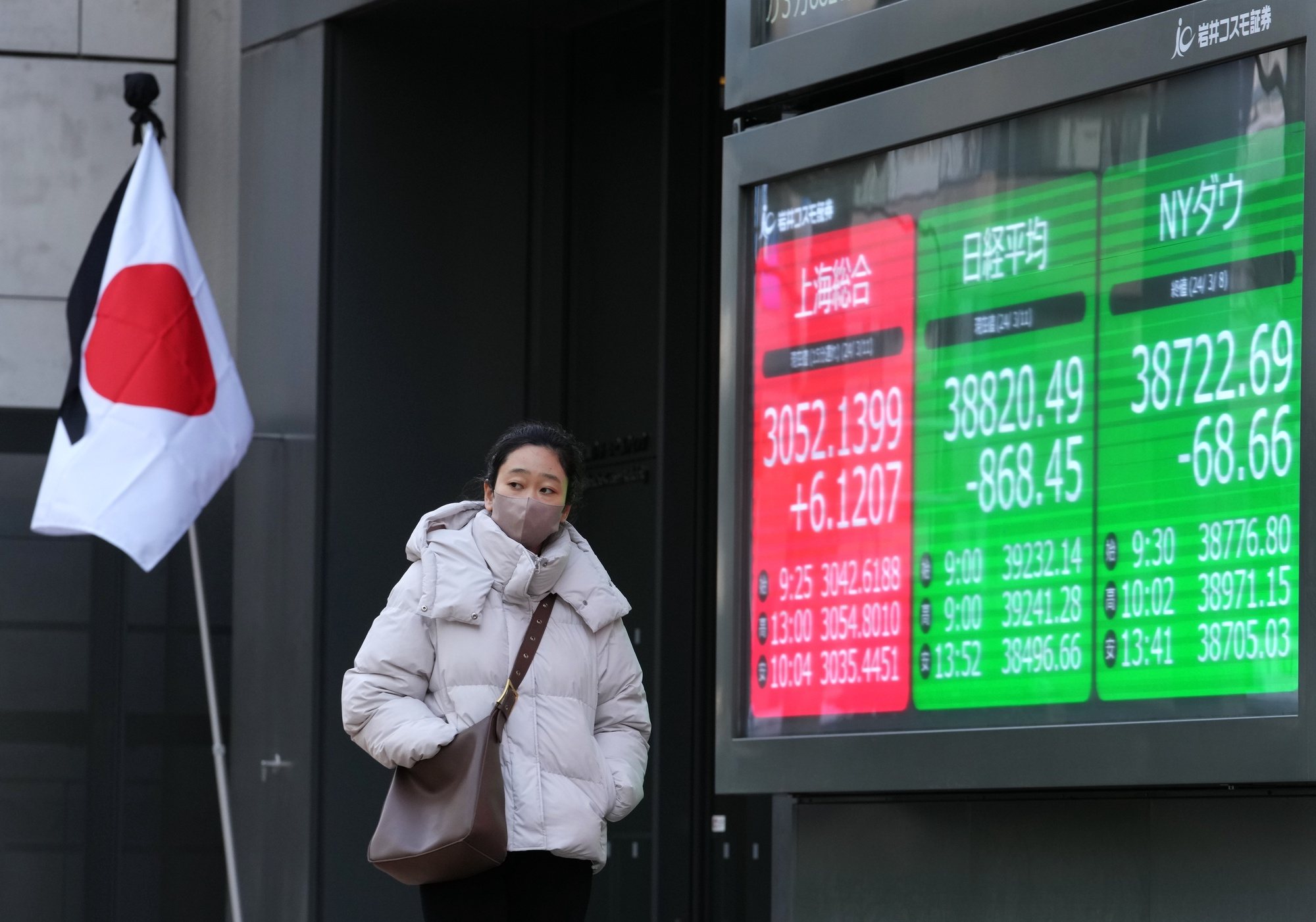 epa11213711 A pedestrian walks past a display showing the closing information of the Nikkei Stock Average in Tokyo, Japan, 11 March 2024. Tokyo&#039;s stock benchmark tumbled 868.45 points, or 2.19 percent, to close at 38,820.49 after climbing over 40,000 points previous week.  EPA/KIMIMASA MAYAMA