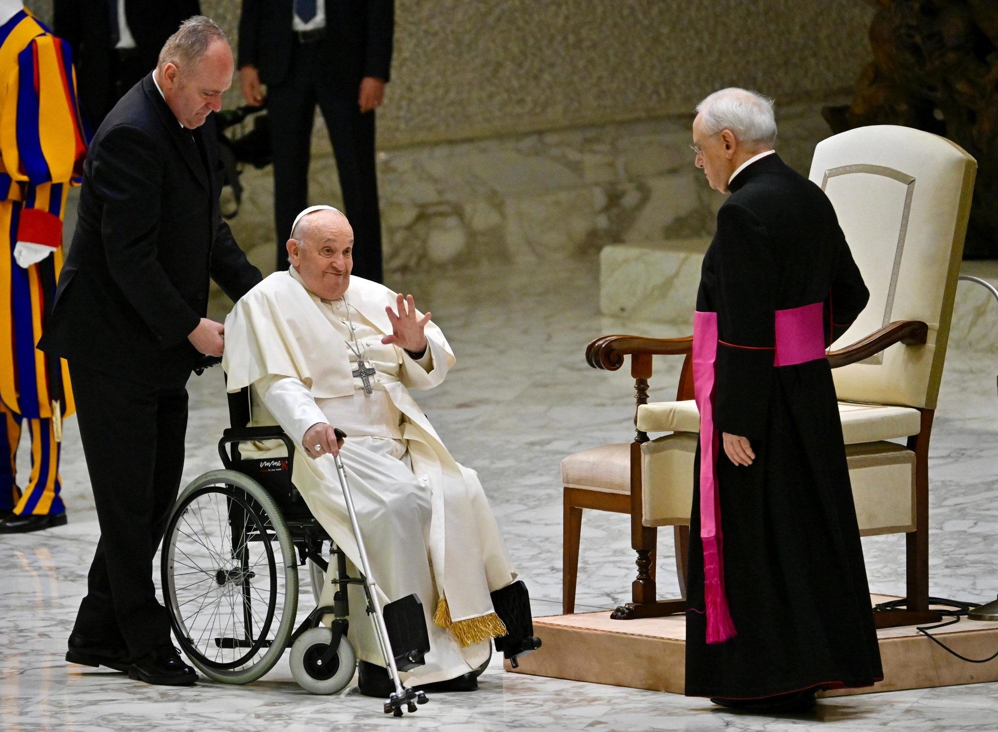 epa11246397 Pope Francis (C), sitting on a wheelchair, waves at the end of his weekly general audience in the Paul VI Audience Hall in Vatican City, 27 March 2024.  EPA/ALESSANDRO DI MEO