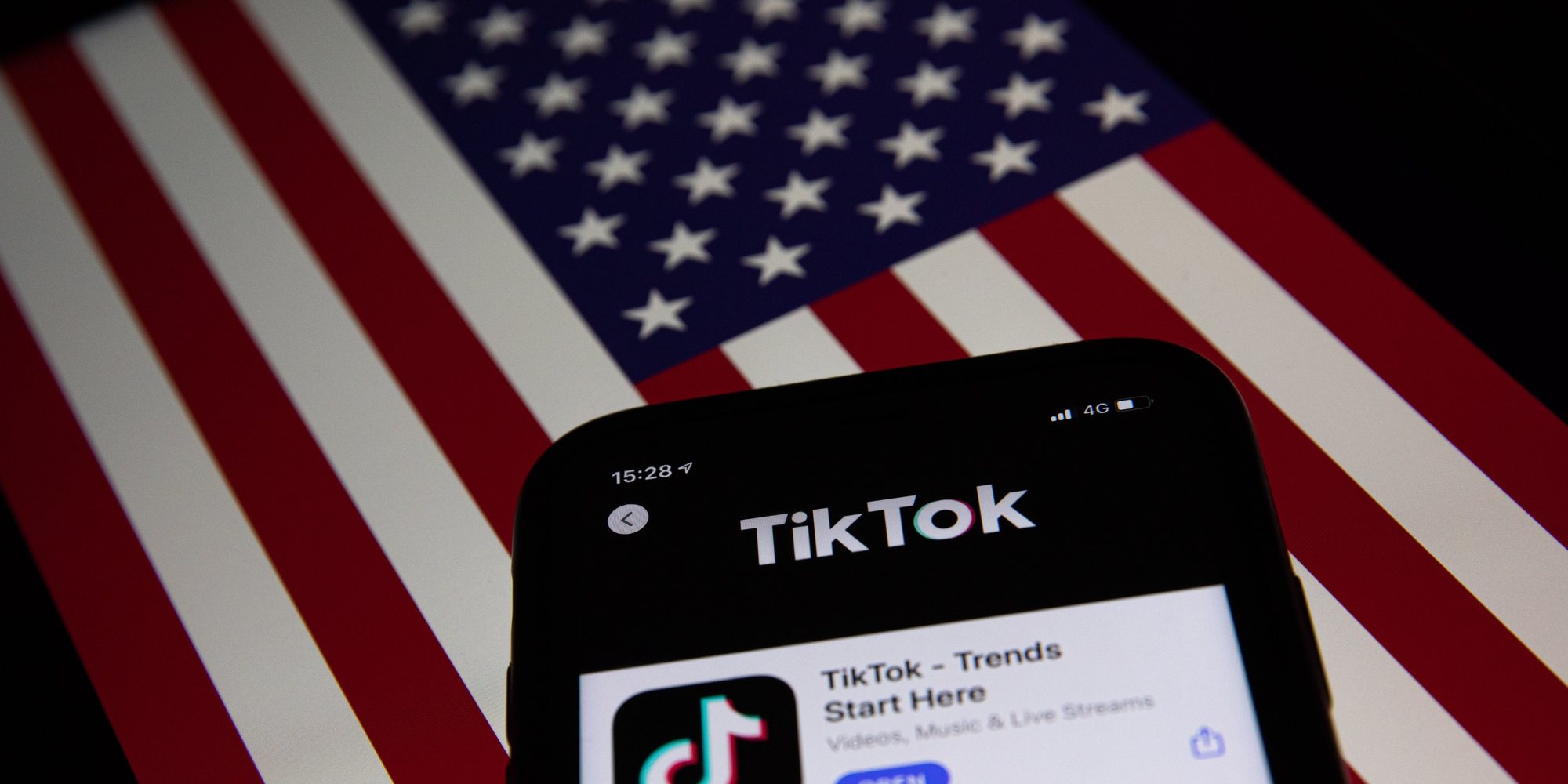 epa08685860 A generic illustration shows the icon of Chinese internet media app TikTok on a phone, and the US flag on a laptop screen, in Beijing, China, 21 September 2020. Chinese-owned mobile app WeChat was set to stop operation in the U.S. on midnight 20 September 2020.  EPA/ROMAN PILIPEY