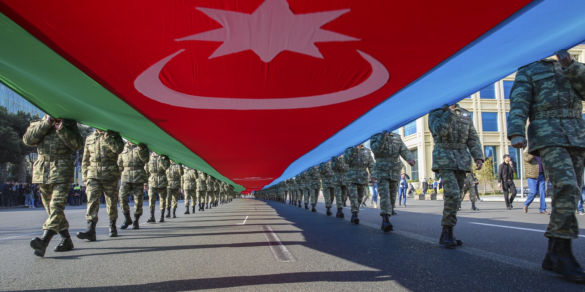 epa09571061 Azeri soldiers carry a large-scale national flag on the anniversary of the end of the 2020 war over the Nagorno-Karabakh region between Azerbaijan and Armenia, in downtown Baku, Azerbaijan, 08 November 2021. On 10 November 2020, a joint statement was published by the President of Azerbaijan, the Prime Minister of Armenia and the President of Russia on the complete cessation of all hostilities in the zone of the Nagorno-Karabakh conflict from 00:00 Moscow time.  As a result of the war, Baku regained a number of territories lost in the early 1990s. According to information disseminated by the Azerbaijani Ministry of Defense, some 2,783 Armed Forces servicemen were killed in the armed conflict.  EPA/ROMAN ISMAYILOV