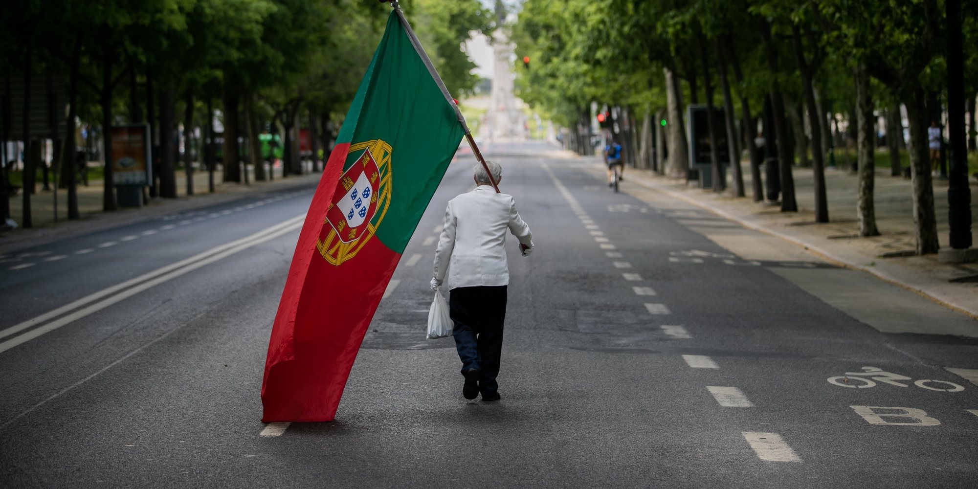 CONJUNTO DE 30 FOTOGRAFIAS SOBRE UM ANO DE ESTADO DE EMERGÊNCIA: 16-30: Foto datada de 25/04/2020: Um homem com uma bandeira de Portugal sobe a Avenida da Liberdade em Lisboa, por volta das 15 horas, altura em que anualmente se realiza um desfile comemorativo do 25 de abril de 1974 e que, devido à pandemia da covid-19, não pode ter lugar, em Lisboa, 25 de abril de 2020. Os 46 anos do 25 de Abril estão a ser hoje celebrados de forma diferente em Portugal, com uma sessão solene reduzida no parlamento, sem o tradicional desfile e com um apelo para que os portugueses cantem a ‘Grândola&#039; à janela. JOSÉ SENA GOULÃO/LUSA