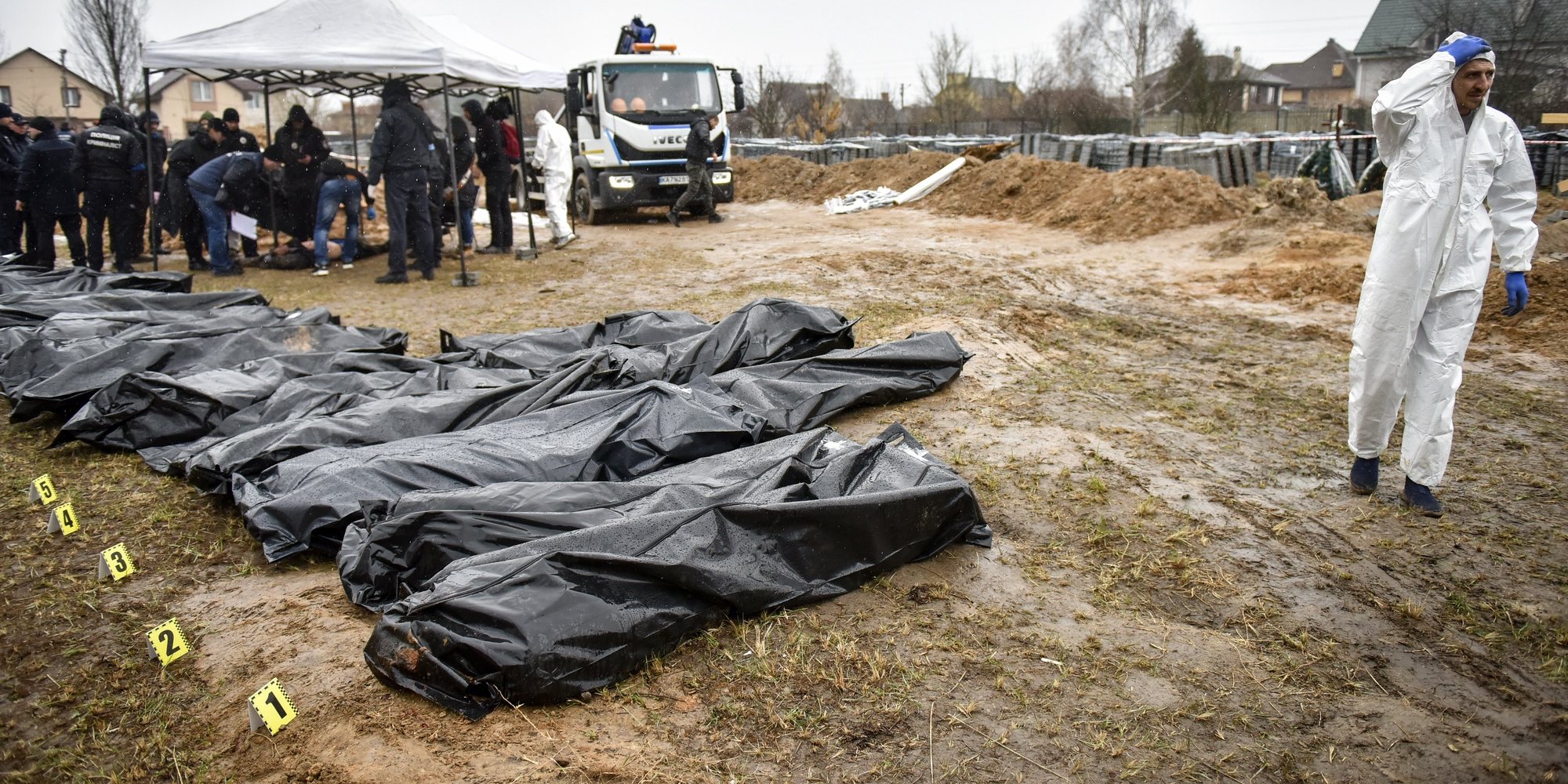 epa09878617 Forensic police officers exhume bodies from a mass grave discovered in Bucha, outskirts of Kyiv (Kiev), Ukraine, 08 April 2022. Ukrainian authorities say that over 400 bodies were discovered following the Russian army’s retreat from towns surrounding Kyiv, prompting international calls for a probe into possible war crimes committed by Russia.  EPA/OLEG PETRASYUK