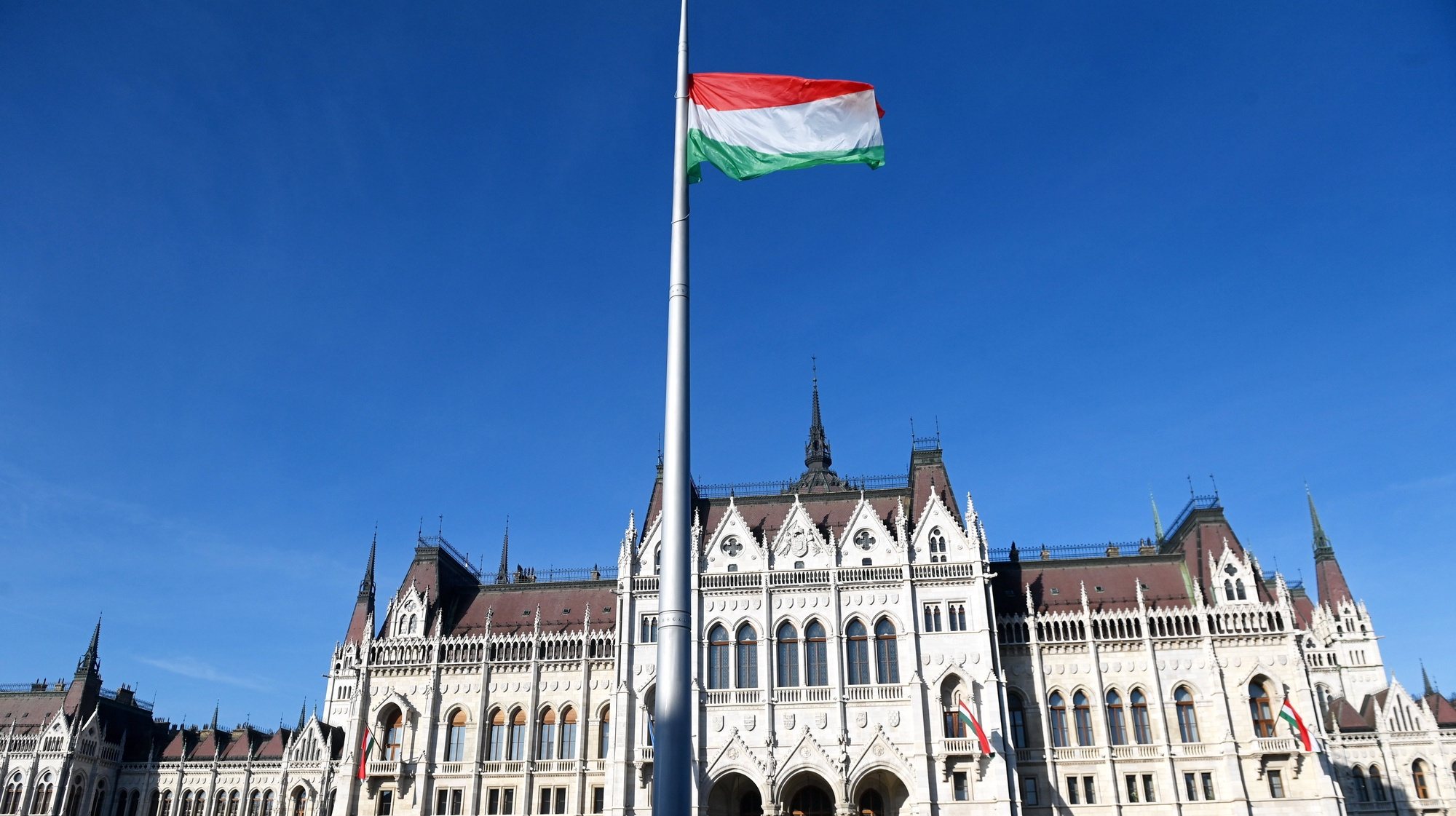 epa10260556 The Hungarian flag flies after being hoisted by honor guards during the state commemoration of the national holiday marking the 66th anniversary of the outbreak of the Hungarian revolution and war of independence against communist rule and the Soviet Union in 1956, at the Parliament building in Budapest, Hungary, 23 October 2022.  EPA/Noemi Bruzak HUNGARY OUT