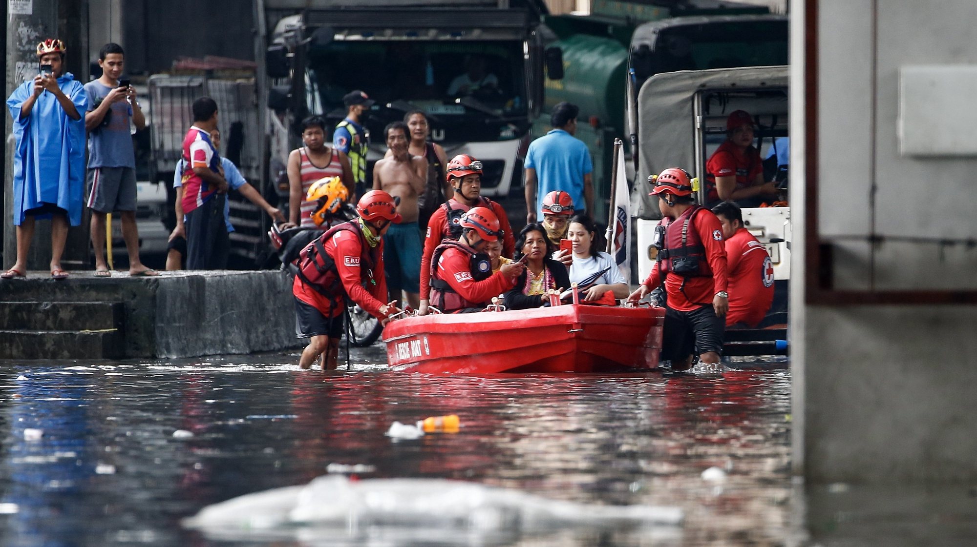 epa10830382 An emergency response team uses a rescue boat to help transport residents along a flooded road in Quezon City, Metro Manila, Philippines, 31 August 2023. Typhoon Saola, which has left the Philippine Area of Responsibility, and Tropical Storm Haikui off the coast of extreme northern provinces are enhancing a southwest monsoon bringing rains in the western Luzon region of the country, according to data from the Philippine Atmospheric Geophysical and Astronomical Services Administration (PAGASA). Figures from the National Disaster Risk Reduction and Management Council (NDRRMC) show that over 305,000 individuals were affected by the passing of Typhoon Saola.  EPA/ROLEX DELA PENA