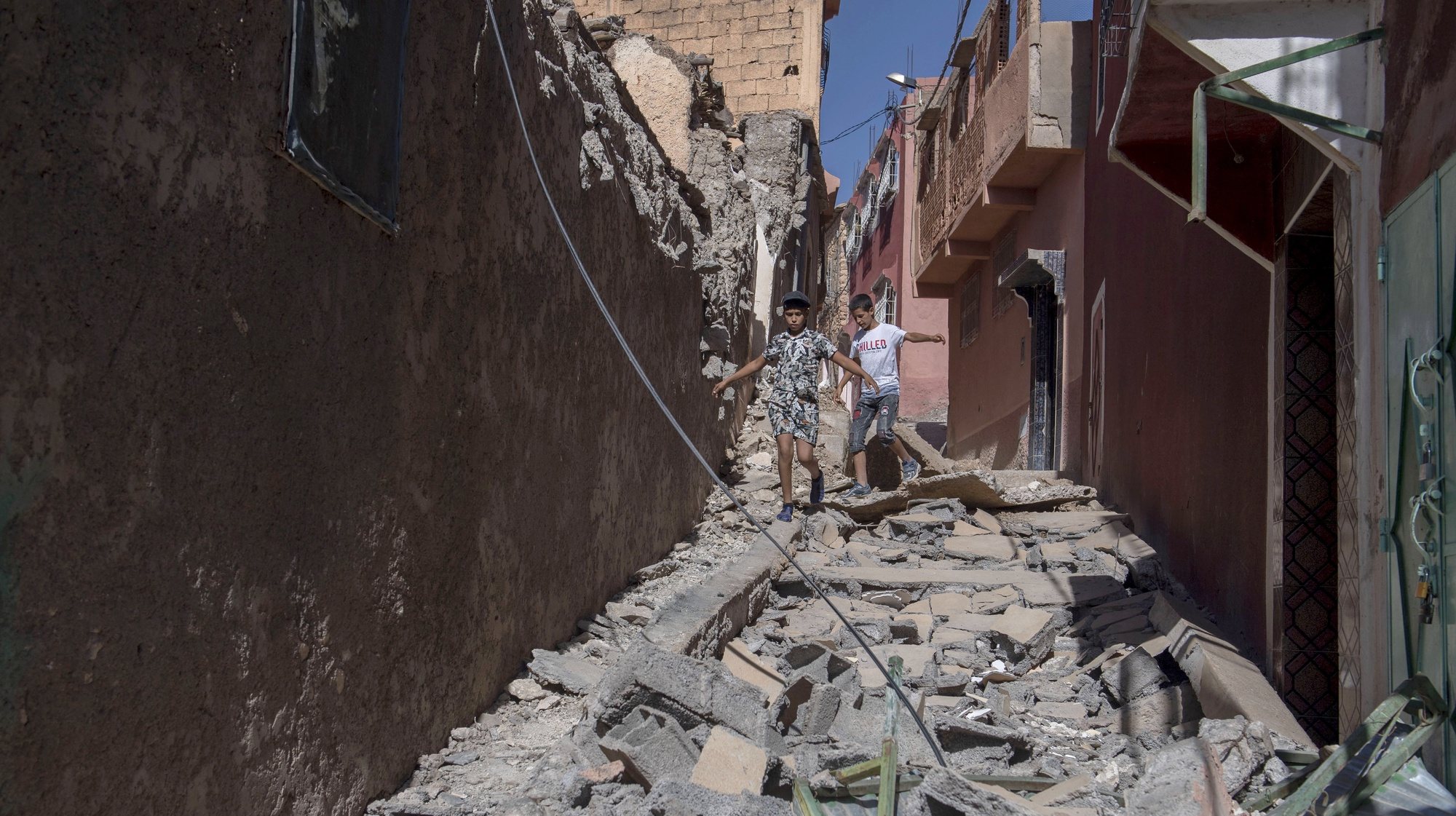 epa10850133 Two children walk among debris of damaged buildings following an earthquake in Marrakesh, Morocco, 09 September 2023. A powerful earthquake that hit central Morocco late 08 September, killed at least 820 people and injured 672 others, according to a provisional report from the country&#039;s Interior Ministry. The earthquake, measuring magnitude 6.8 according to the USGS, damaged buildings from villages and towns in the Atlas Mountains to Marrakesh.  EPA/JALAL MORCHIDI