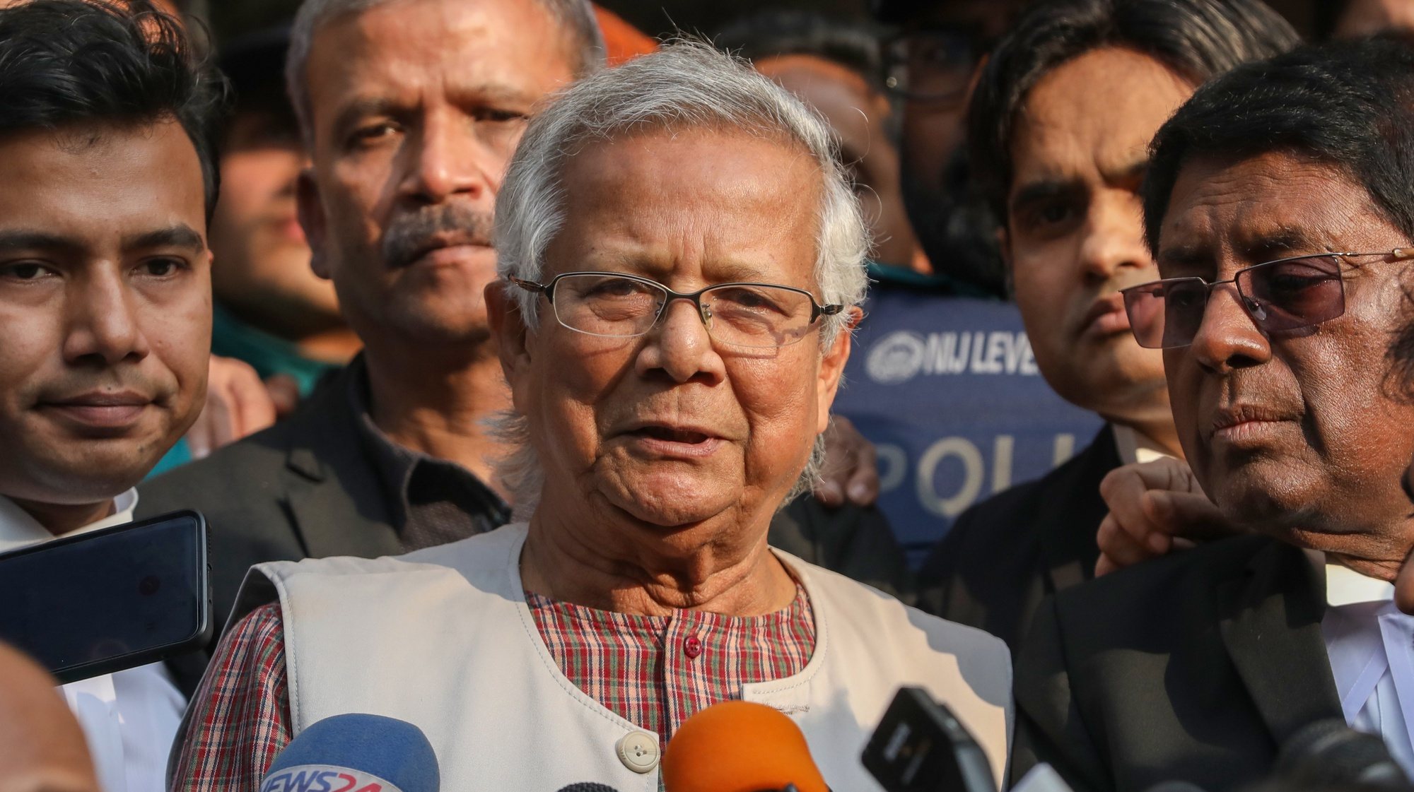 epa11052120 Bangladeshi Nobel peace laureate Muhammad Yunus (C) talks to the media outside the Dhaka Labor Court in Dhaka, Bangladesh, 01 January 2024. Yunus and three other top officials of Grameen Telecom were sentenced to six months of imprisonment in a case over labor law violations.  EPA/MONIRUL ALAM