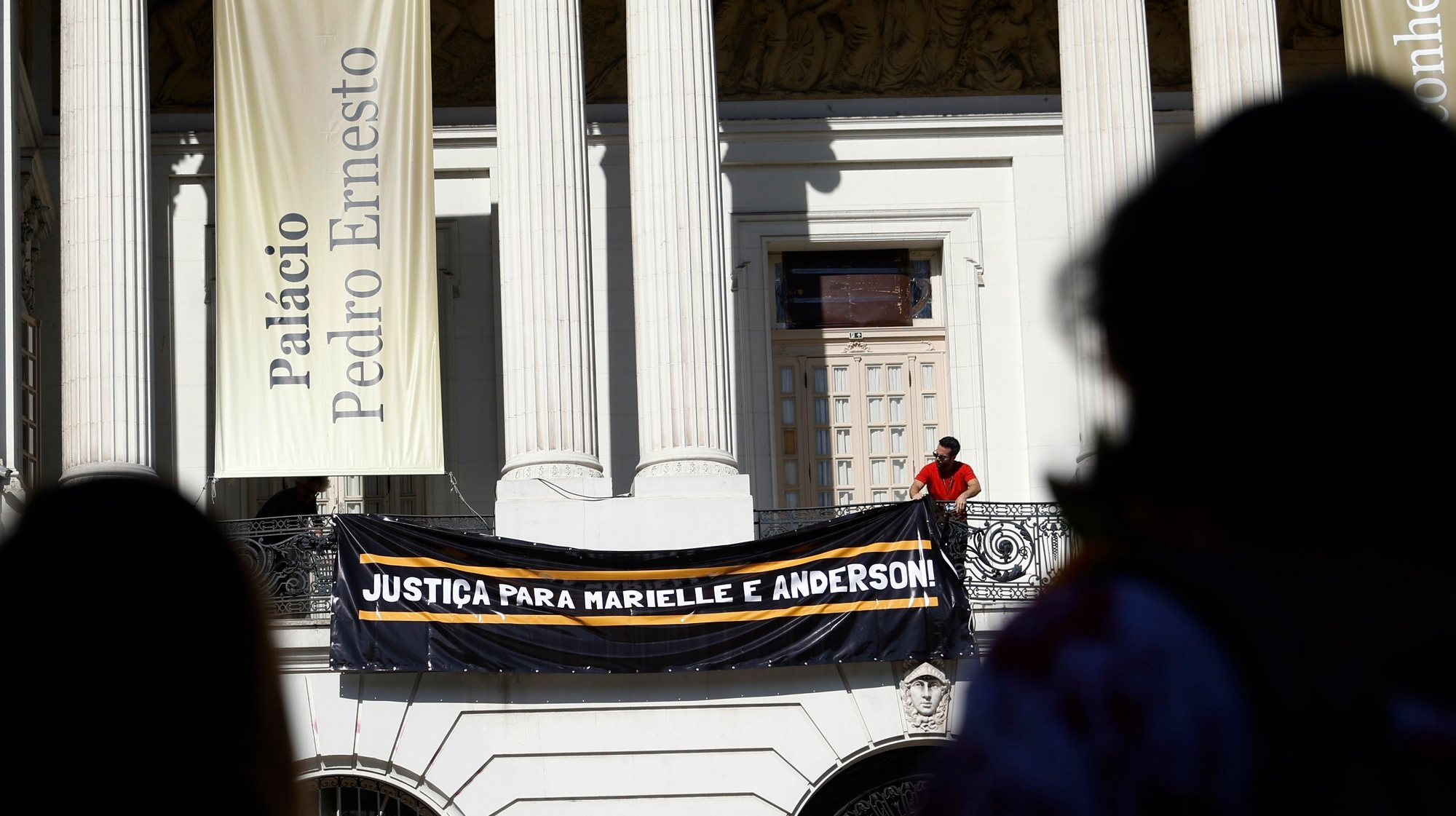 epa11220139 A banner is put on display from a balcony of the Municipal Chamber of Rio de Janeiro that reads &#039;Justice for Marielle and Anderson&#039; during an event to demand justice for Franco&#039;s murder, on the sixth anniversary of her death, on the steps of the Municipal Chamber of Rio de Janeiro, Brazil, 14 March 2024. Dozens of people gathered in front of the Municipal Chamber of Rio to ask for clarification on the murder case of the activist Marielle Franco, who was killed in Rio de Janeiro on 14 March 2018 alongside her driver Anderson Gomes. Although the alleged perpetrators are in prison, it is unknown who ordered the homicide and for what reason.  EPA/Antonio Lacerda