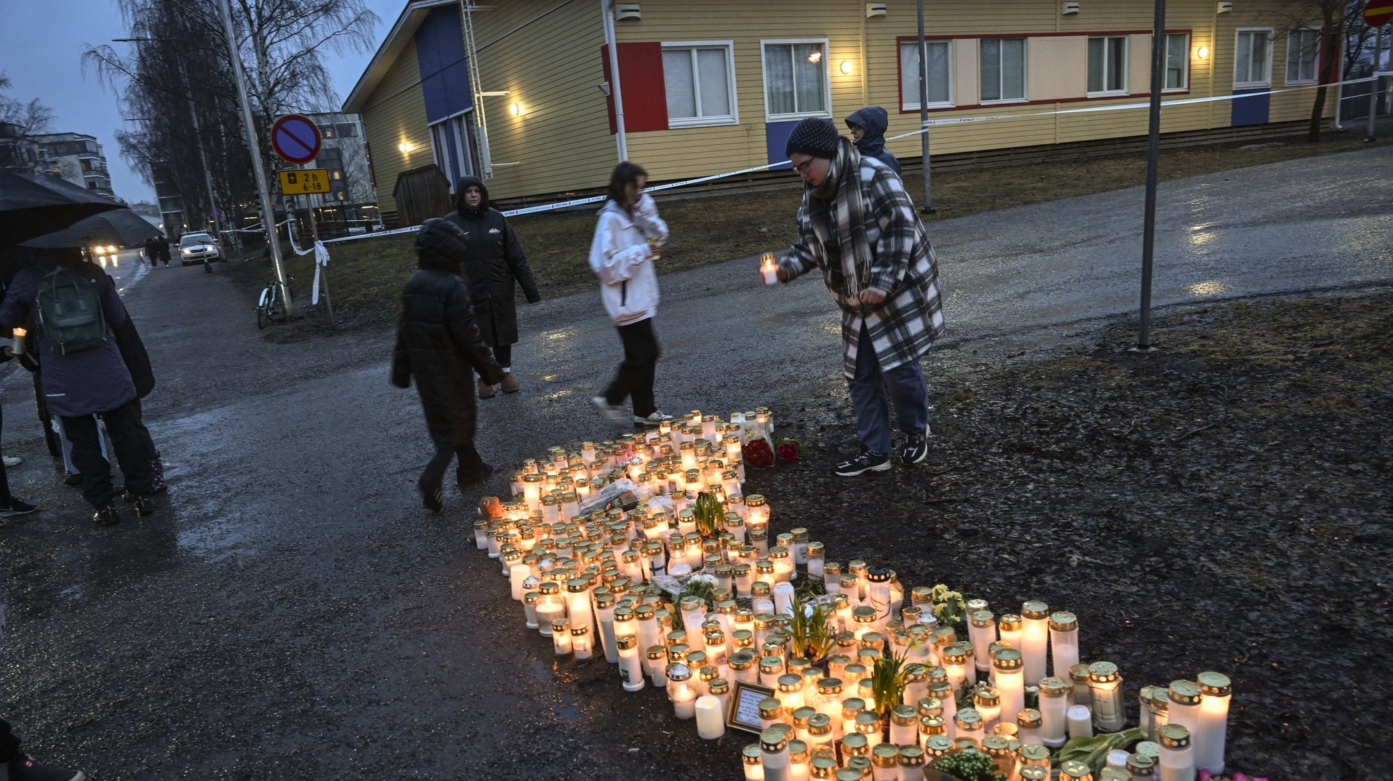 epa11255796 People leave candles in the school yard where a shooting incident took place in Vantaa, Finland, 02 April 2024. According to Police, one 12-year-old child has died and two others are injured in a shooting incident in a school in Vantaa. The suspect, also aged 12, fled the scene but was later arrested.  EPA/KIMMO BRANDT