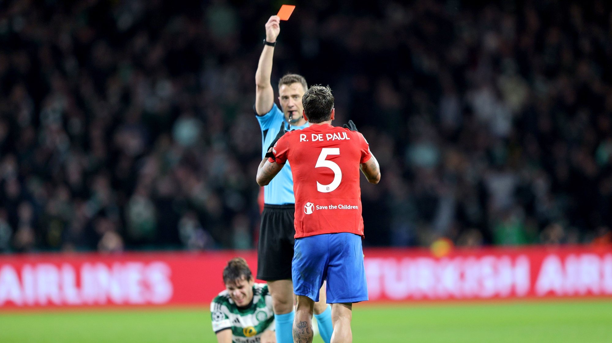 epa10939442 Rodrigo De Paul of Atletico is shown the red card by referee Felix Zwayer following his second yellow card during the UEFA Champions League Group E match between Celtic Glasgow and Atletico Madrid in Glasgow, Britain, 25 October 2023.  EPA/ROBERT PERRY