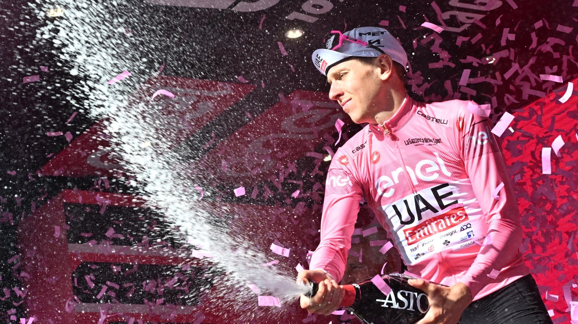 epa11329387 Slovenian rider Tadej Pogacar of UAE Team Emirates celebrates on the podium retaining the overall leader&#039;s pink jersey after the 6th stage of the Giro d&#039;Italia 2024, a cycling race over 180 km from Torre del Lago Puccini (Viareggio) to Rapolano Terme, Italy, 09 May 2024.  EPA/LUCA ZENNARO