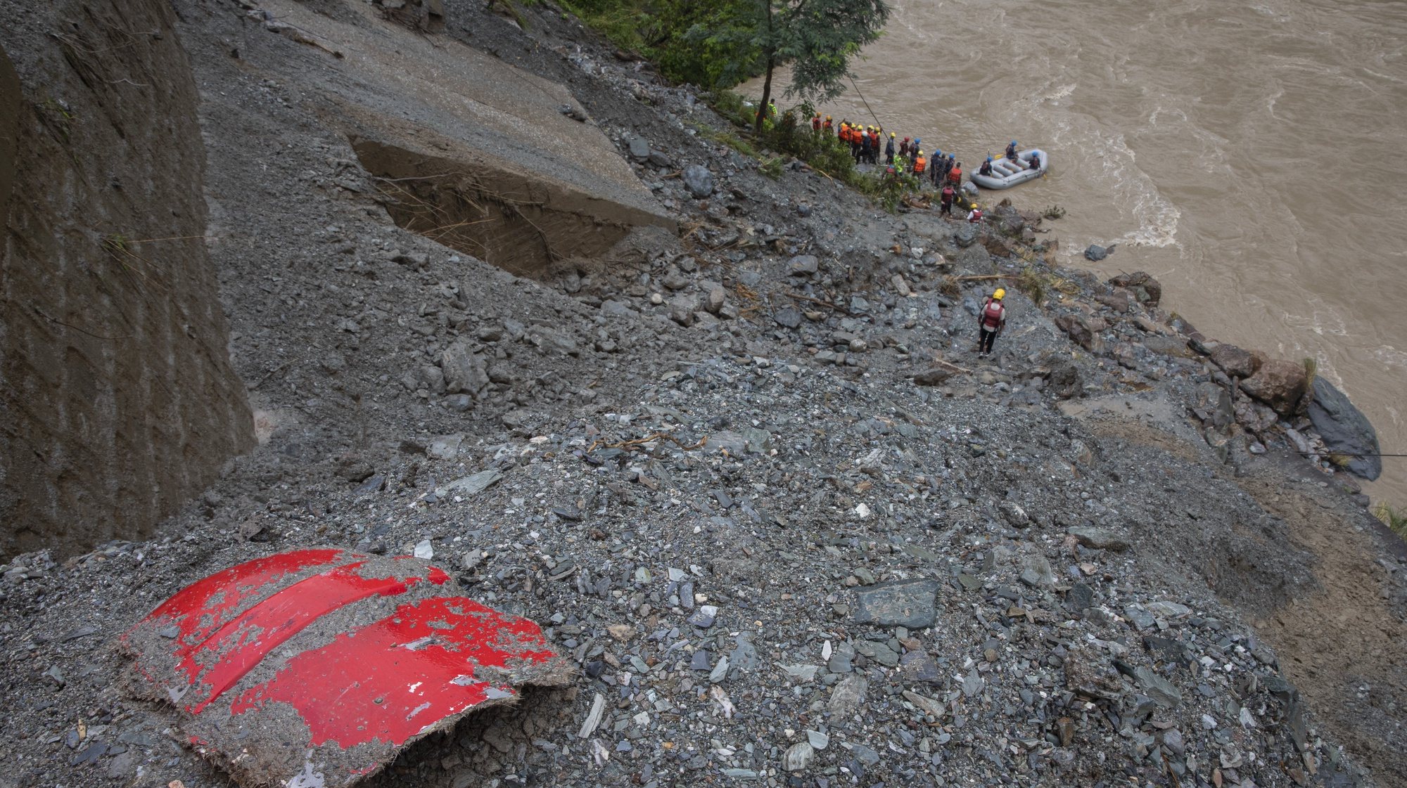 epa11475477 A piece of missing bus which was swept away by a landslide at Trishuli River in Simaltal, Chitwan district, Nepal, 13 July 2024. At least 60 people are missing after two passenger buses were swept away by a landslide that occurred in Simaltal of the Narayanghat-Mugling road section on 12 July.  EPA/NARENDRA SHRESTHA