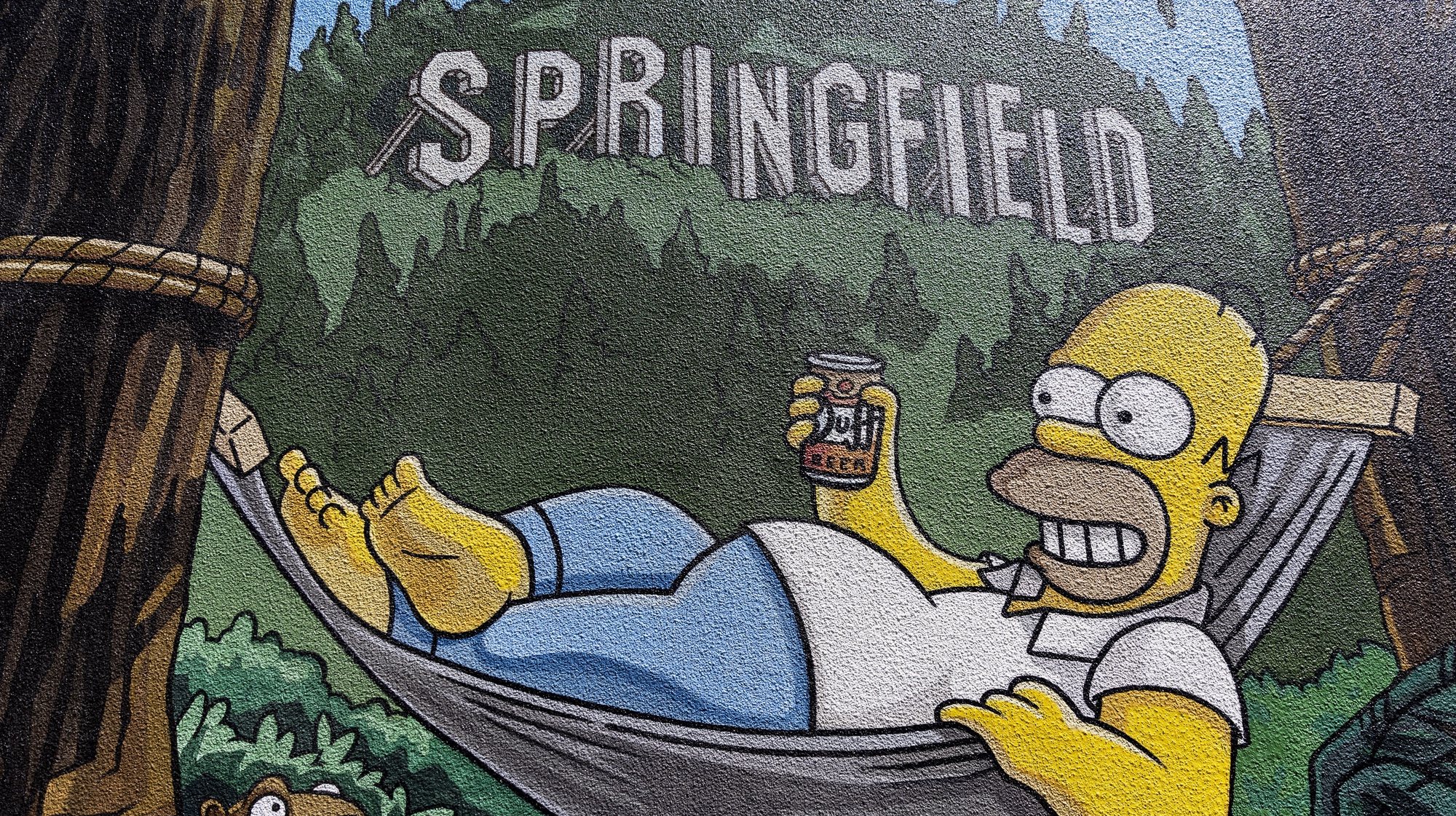 epa10090348 A detail of a mural by Old City Artists shows Homer Simpson on a hammock in Springfield, Oregon, USA, 24 July 2022.  EPA/ETIENNE LAURENT