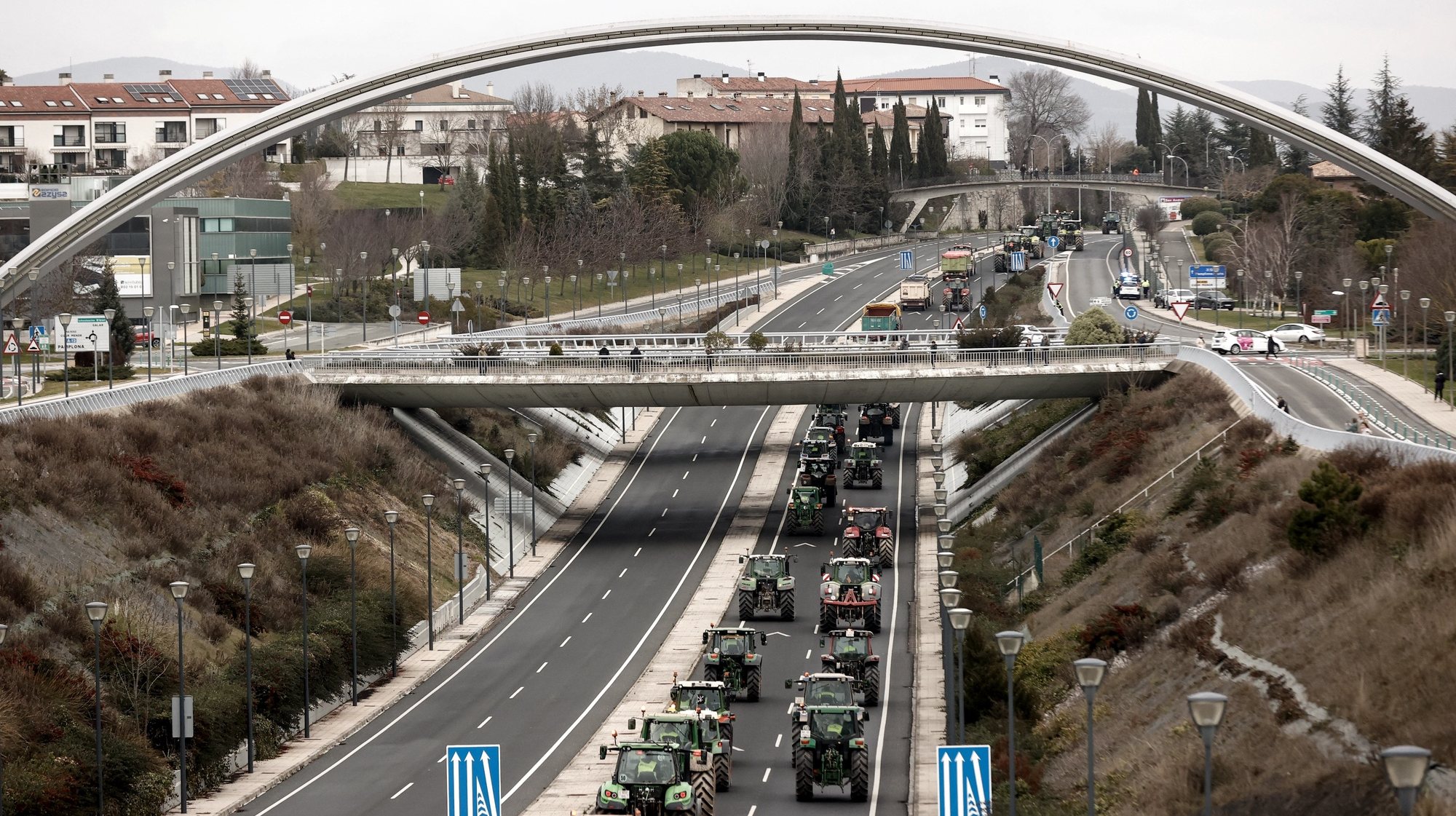 epaselect epa11136615 Farmers drive their tractors as they enter Pamplona after moving by force Civil Guard&#039;s vehicles to reach the city of Pamplona, in Navarra region, northern Spain, 08 February 2024. Farmers continue their protests for a third day in a row throughout Spain to demand a relaxation of the environmental demands imposed by the European Union, fairer trade agreements with third countries, reciprocity in food from third countries and aid for crises such as that generated by the drought, echoing demonstrations in other parts of Europe, including Germany, Belgium and France.  EPA/JESUS DIGES