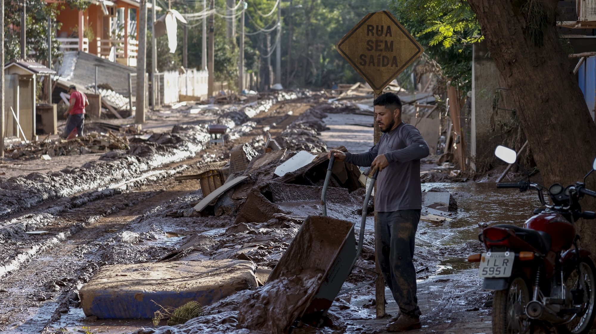 epaselect epa11327657 A man removes the mud that flooded his house after the Taquari river overflowed its banks in Cruzeiro do Sul, Rio Grande do Sul state, Brazil, 08 May 2024. The death toll from catastrophic floods in southern Brazil has exceeded 100, according to the latest figures released by the Civil Defense on 08 May.  EPA/SEBASTIAO MOREIRA