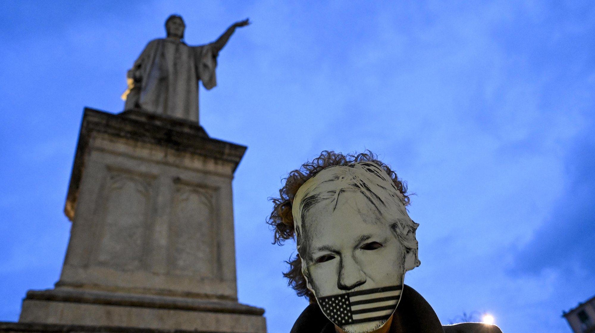 epaselect epa11245138 A supporter of WikiLeaks founder Julian Assange wears a face mask while demonstrating among others near the Monument to Dante in Naples, Italy, 26 March 2024. According to a press statement by Courts and Tribunals Judiciary on 26 March, the High Court has granted Assange conditional permission to appeal his extradition to the US. The US was given a three weeks period to ensure that Assange will not be sentenced to death, that he will be afforded his first amendment rights (free speech) and that his Australian nationality will not be a prejudice in case of trial. The next hearing is due for 20 May, to review whether the latest conditions have been met.  EPA/CIRO FUSCO