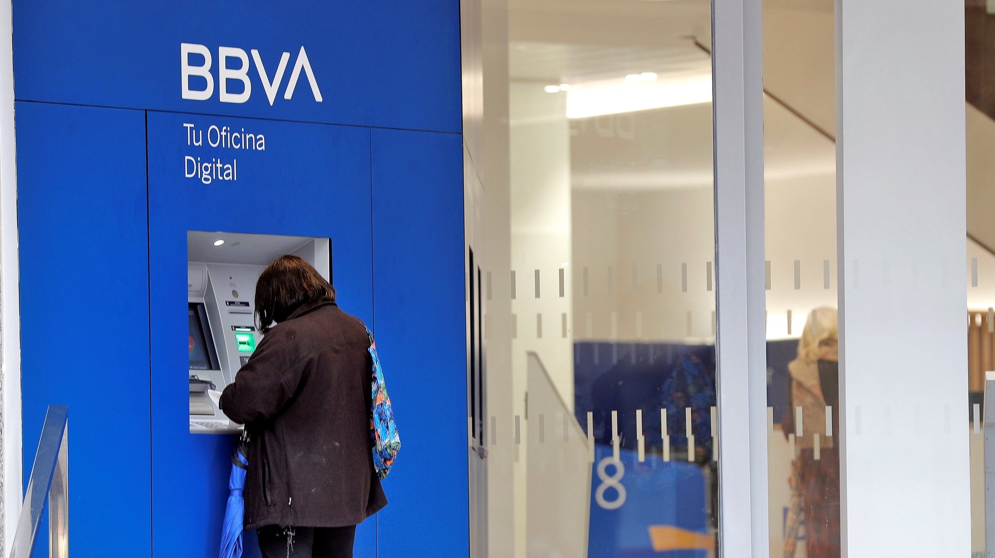 epa08300208 A woman withdraws cash from an ATM at a local branch of the BBVA bank in Valencia, eastern Spain, 17 March 2020. Spain faces its third day of the state of emergency declared by the Spanish authorities over the ongoing pandemic of the COVID-19 disease caused by the SARS-CoV-2 coronavirus.  EPA/MANUEL BRUQUE