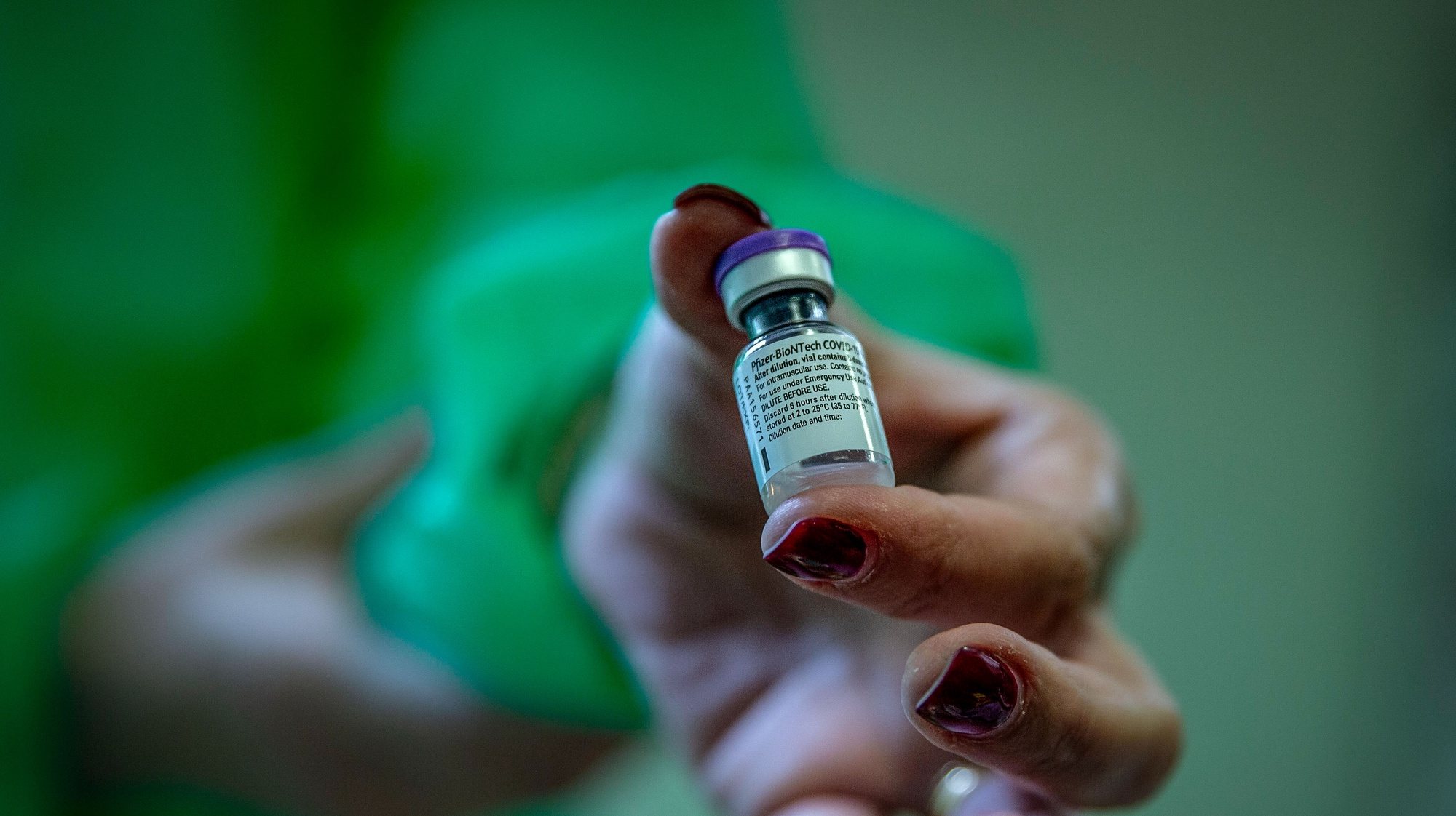 Uma enfermeira mostra a vacina contra a covid-19 durante a vacinação dos profissionais de saúde da Santa Casa Misericórdia de Vila Franca do Campo, em Vila Franca, Ilha de São Miguel, nos Açores, 31  de dezembro de 2020. EDUARDO COSTA /LUSA